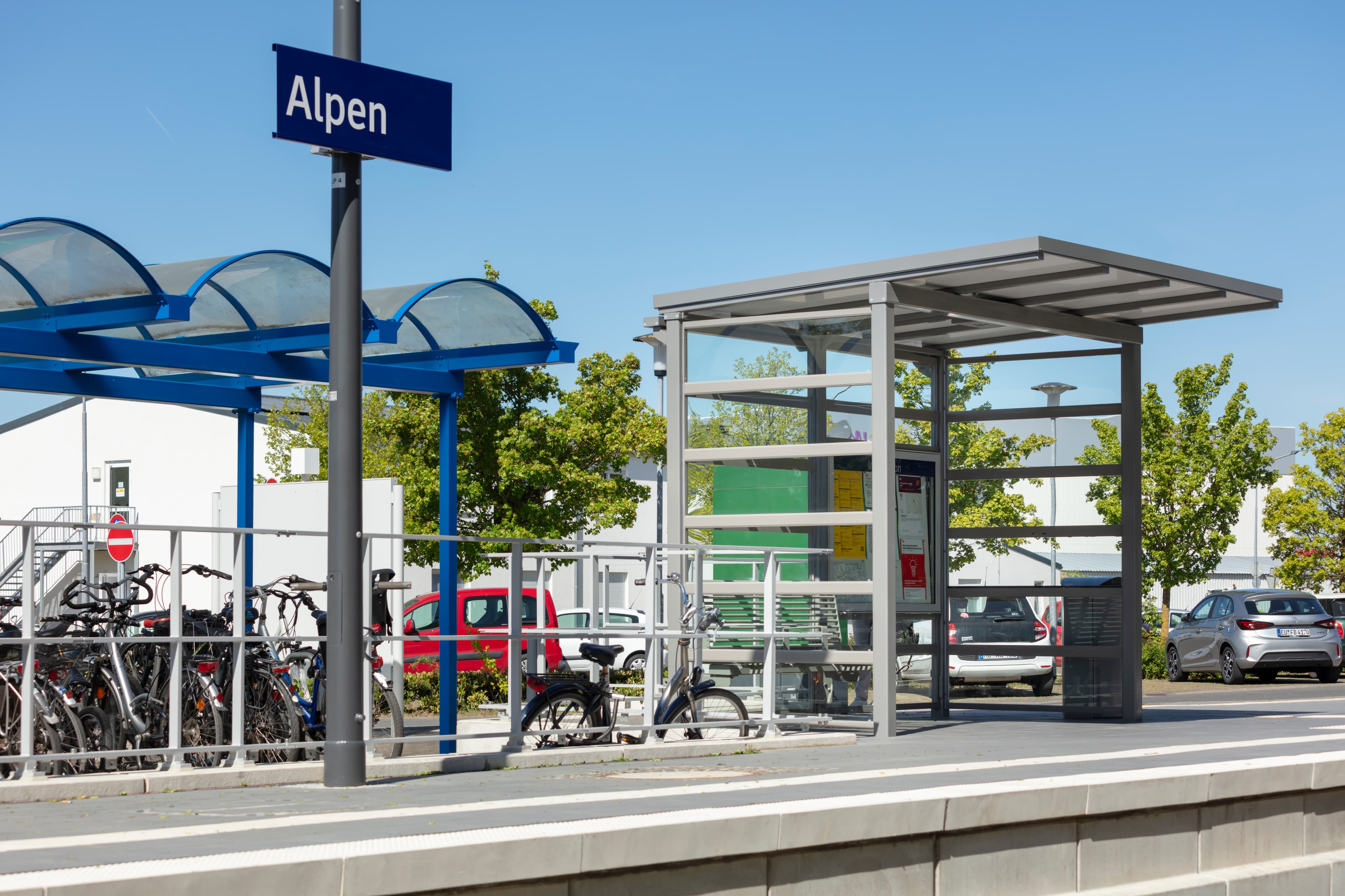 Der Blick auf den Bahnsteig mit einem neuen Wetterschutzhaus und einer Calidum Sitzbank des Bahnhofs Alpen nach der Aufwertung.