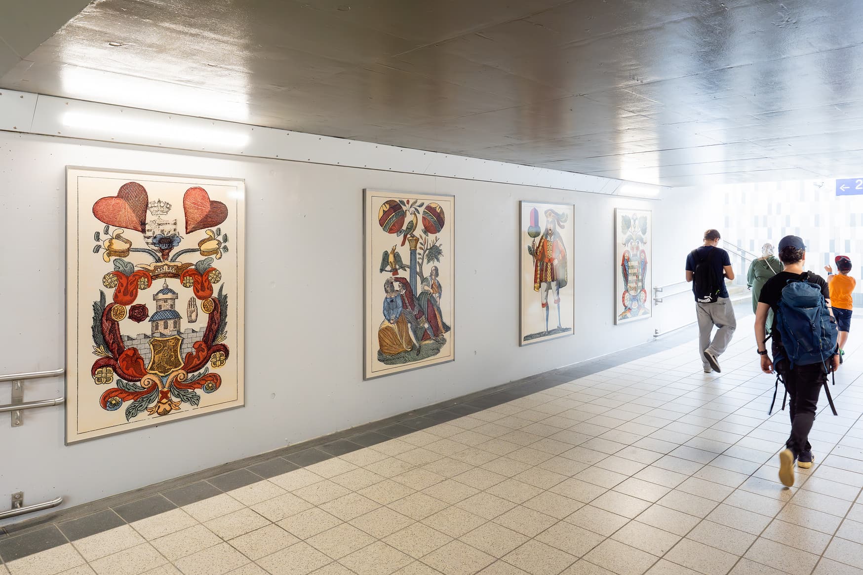 Teil des sanierten Tunnels mit großen Bildern an der Wand, die historische Skatkarten zeigen.