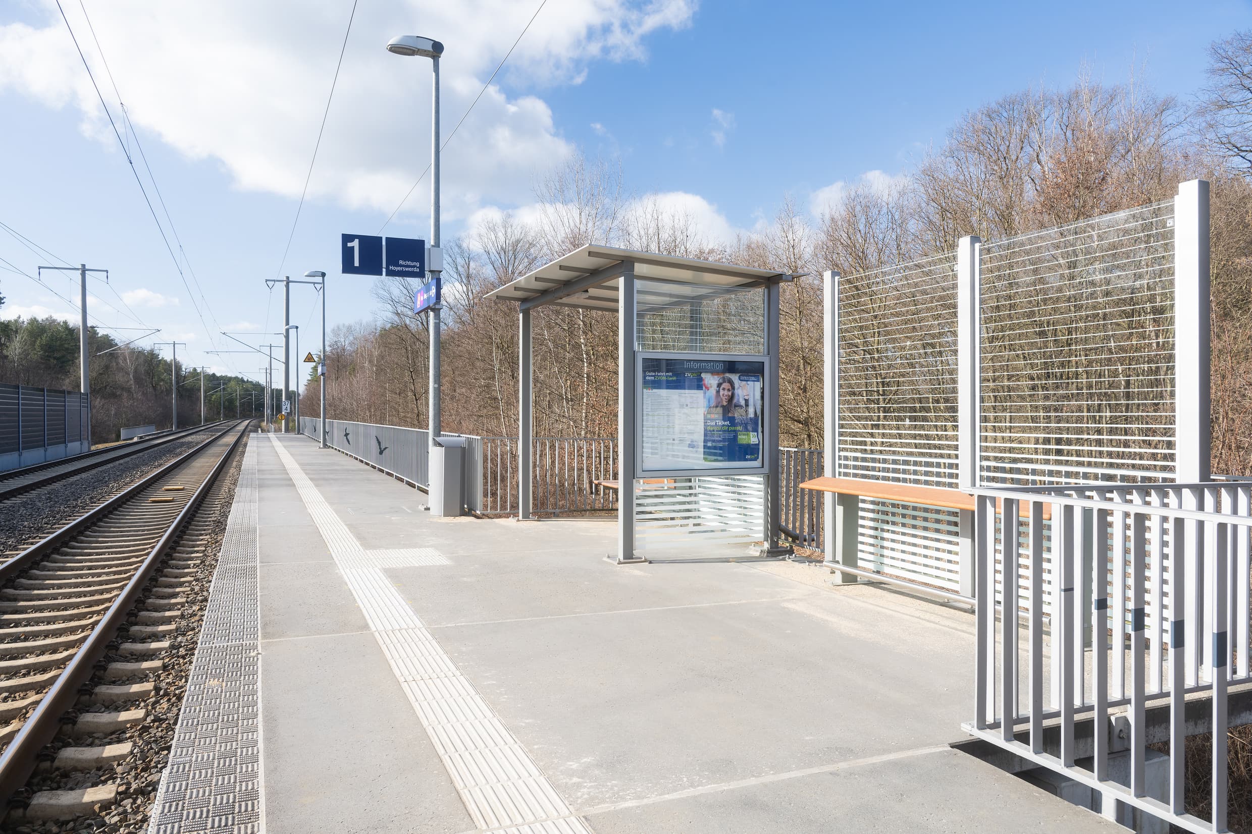 Blick auf den Bahnsteig mit zusätzlichem Anlehner, neuer Bank und Vogelsilhouetten auf dem Geländer