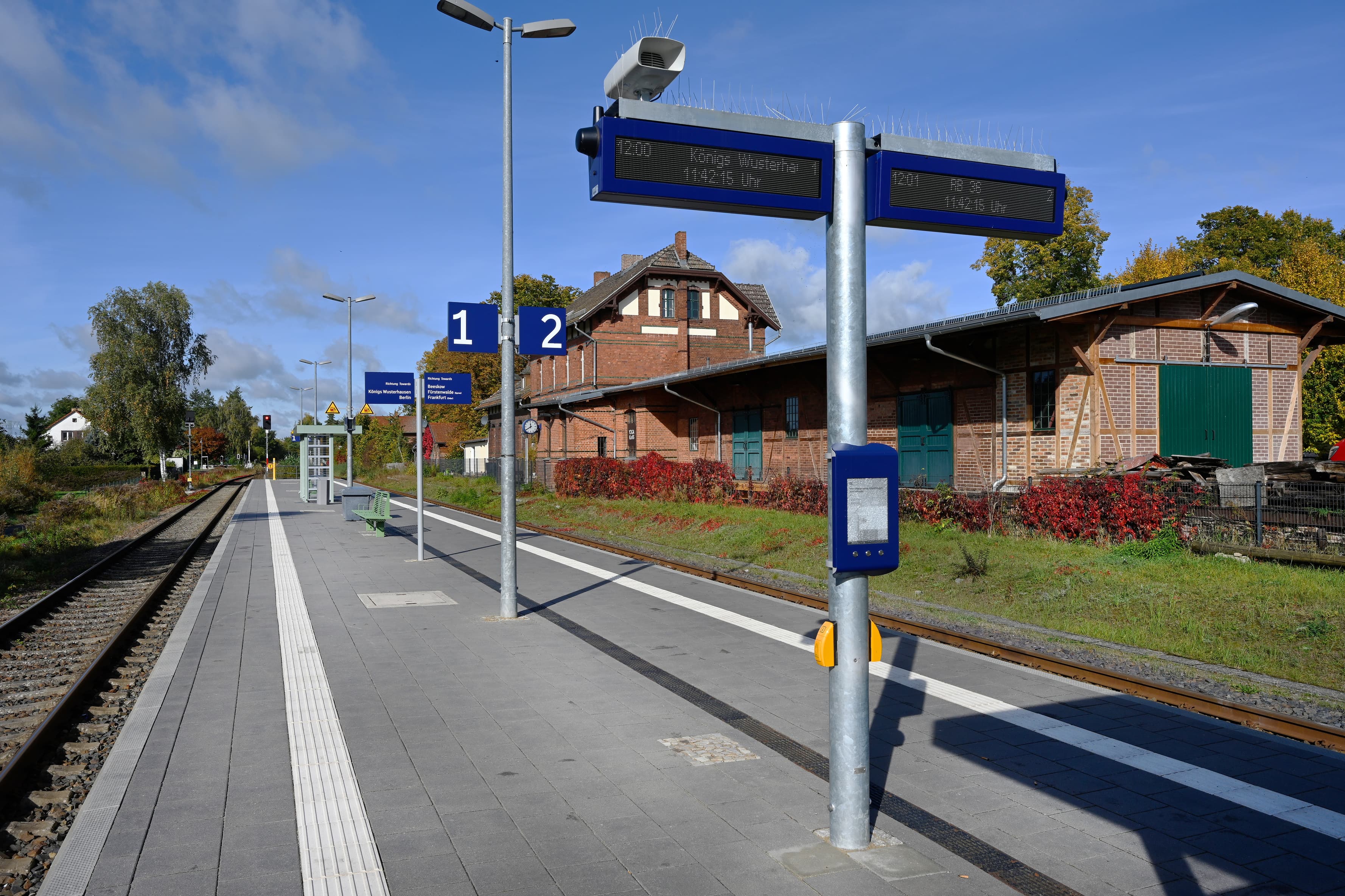 Ein Bahnsteig mit Monitoren und Schildern.