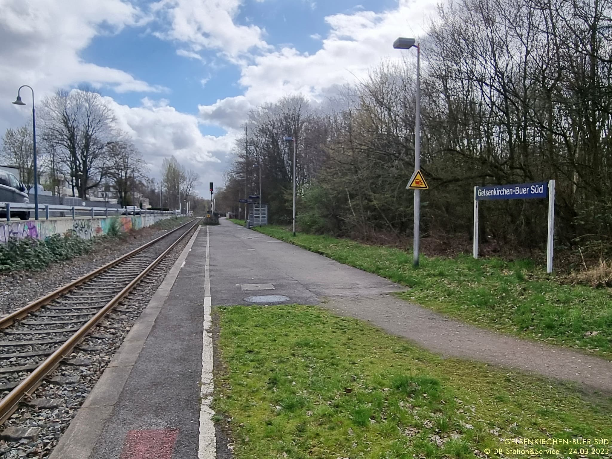 Links befindet sich das Gleis. Rechts der Bahnsteig ohne taktiles Leitsystem und Sitzmöglichkeiten.