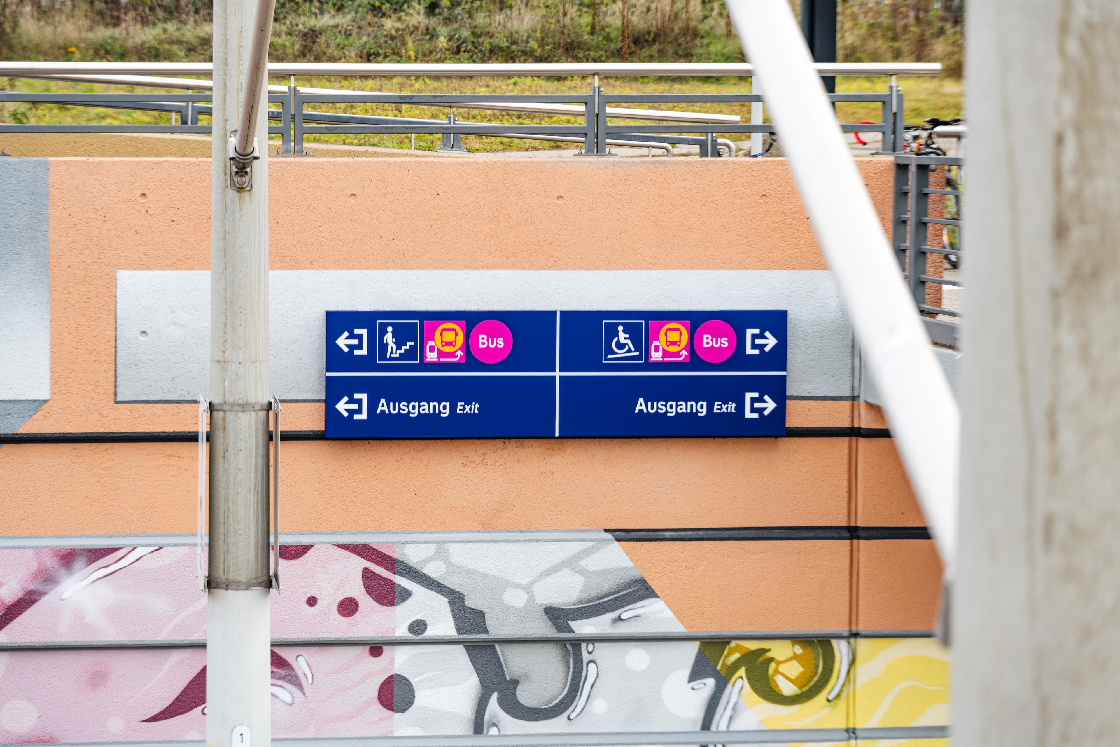 Man sieht ein großes Wegeleitungsschild, was zwei Ausgänge ausweist inkl. eines möglichen Schienenersatzverkehrs. 