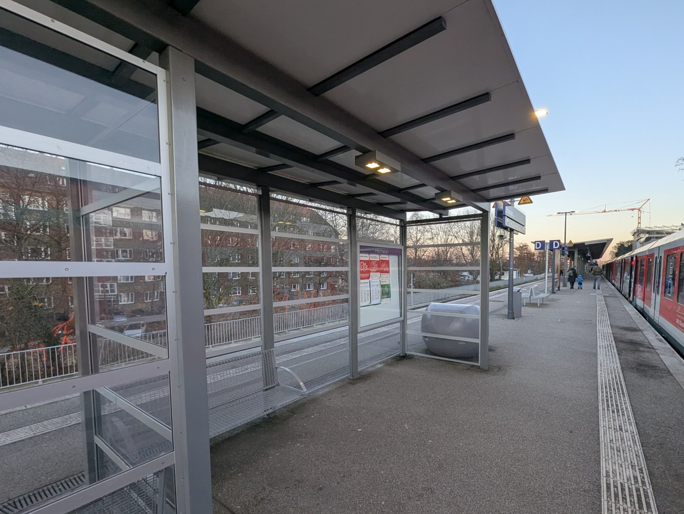 Ein volltransparentes Wetterschutzhäuschen auf dem Bahnsteig.