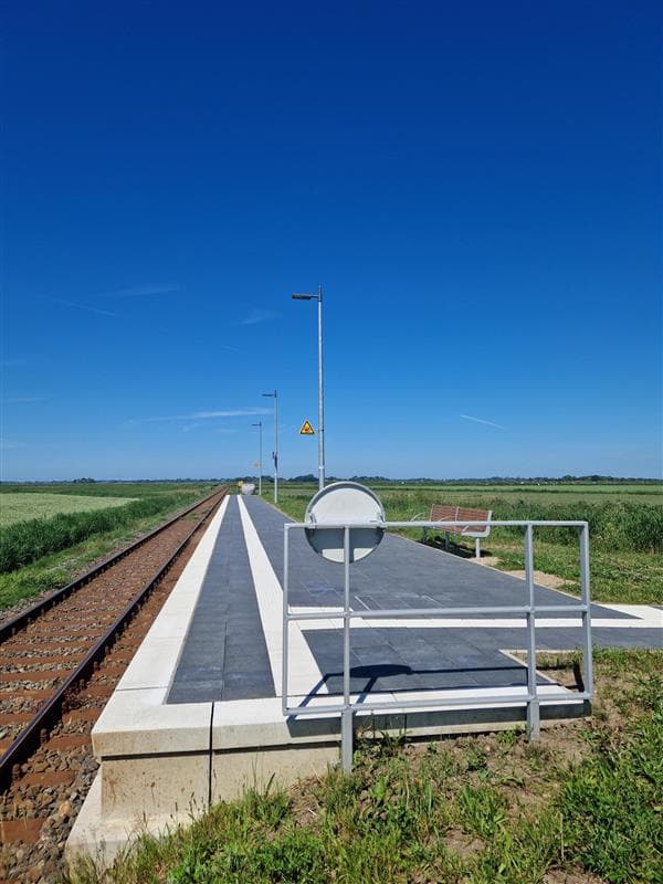 Der Haltepunkt in Kating mit Blick auf weite Felder und Wiesen.