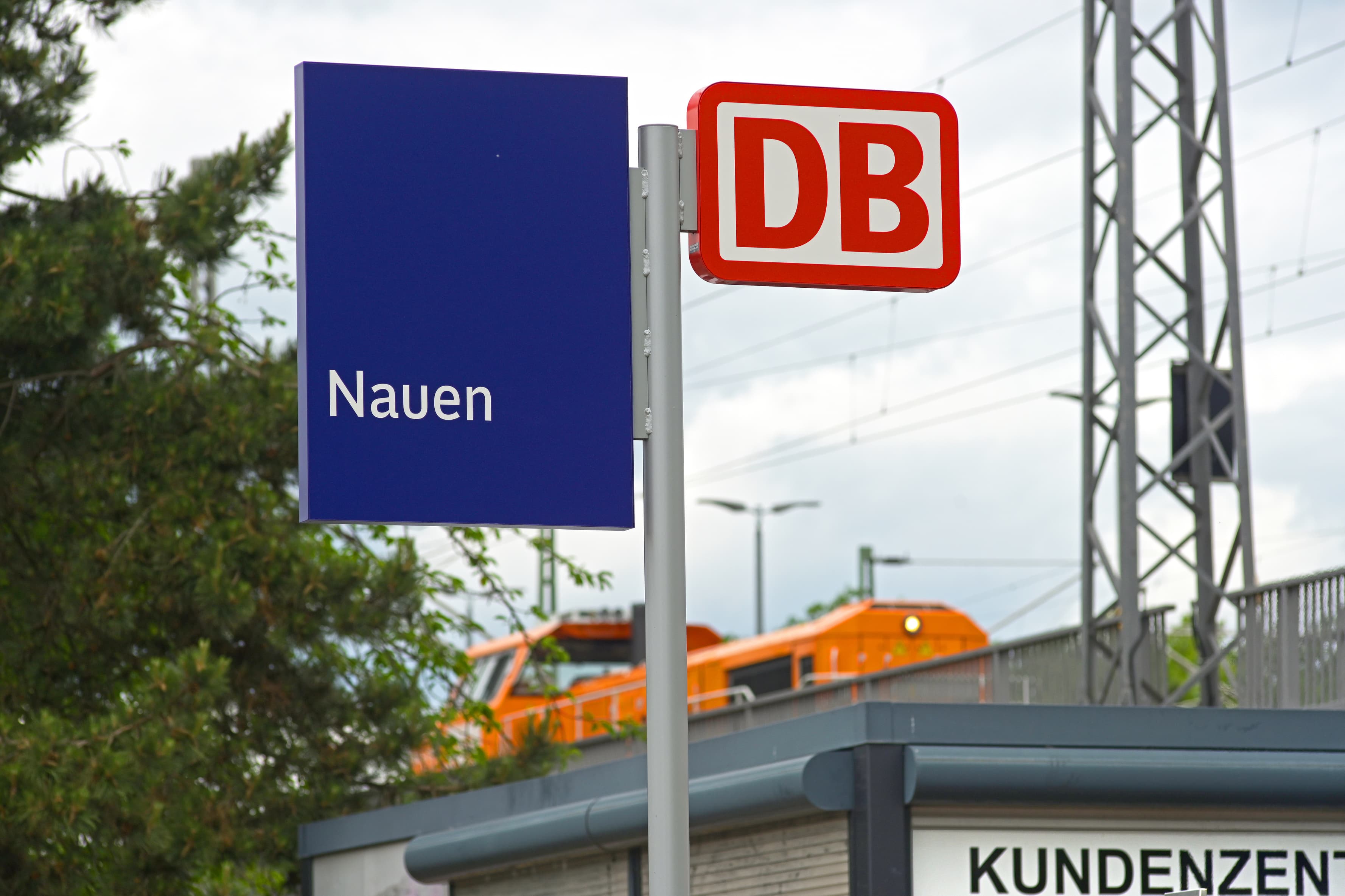 Ein Stationsmast mit dem Bahnhofsnamensschild.