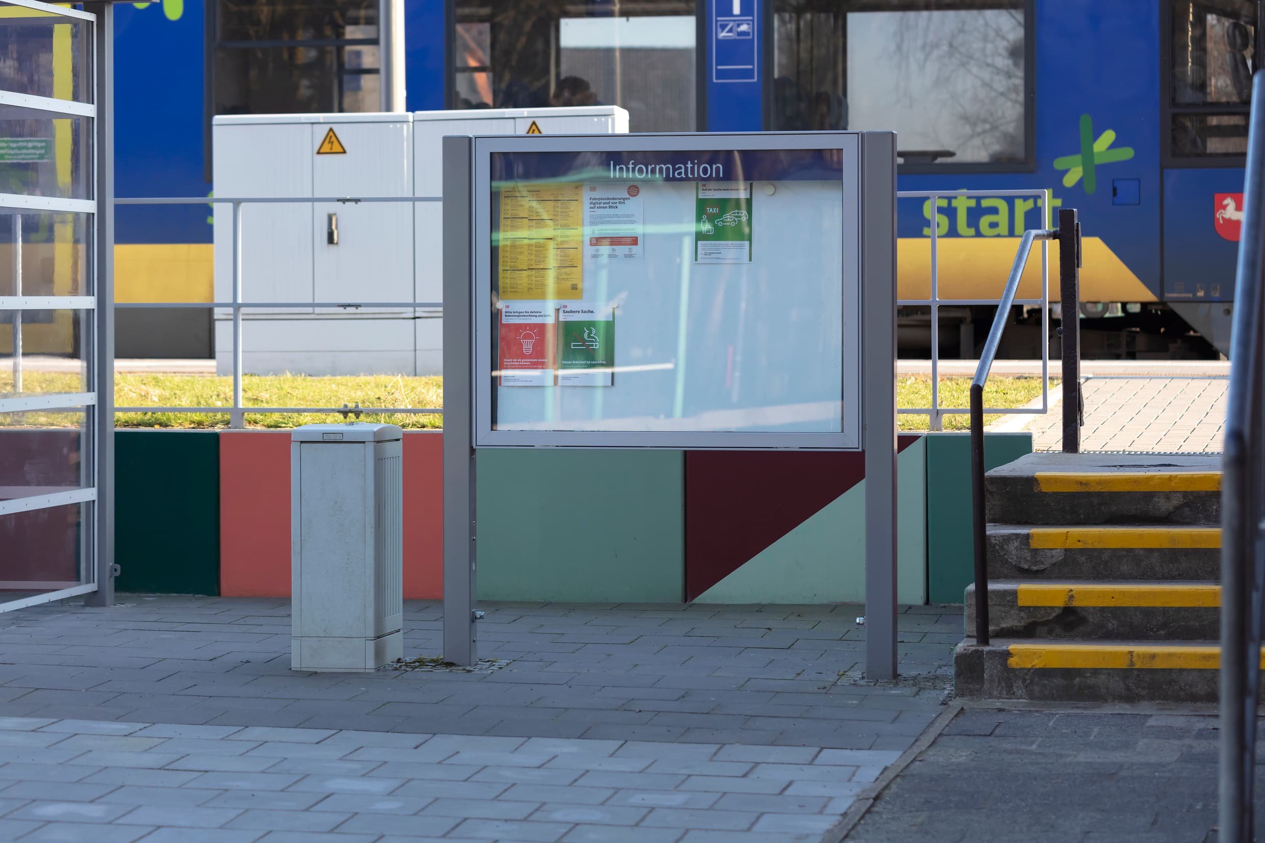 Bunt bemalter Bahnsteigzugang mit Vitrine.