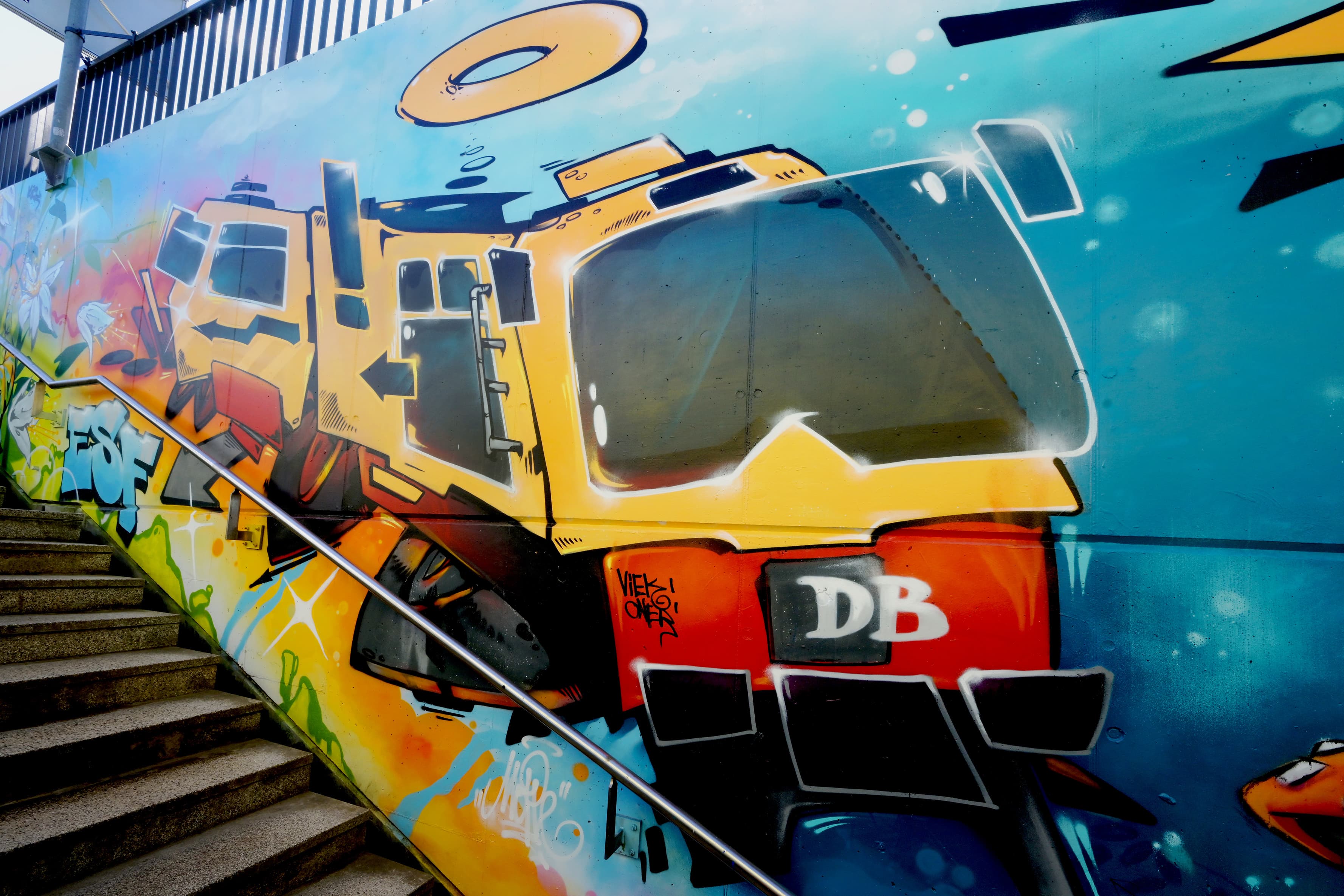 Ein buntes Zug-Motiv an einer Wand im Bahnhof.