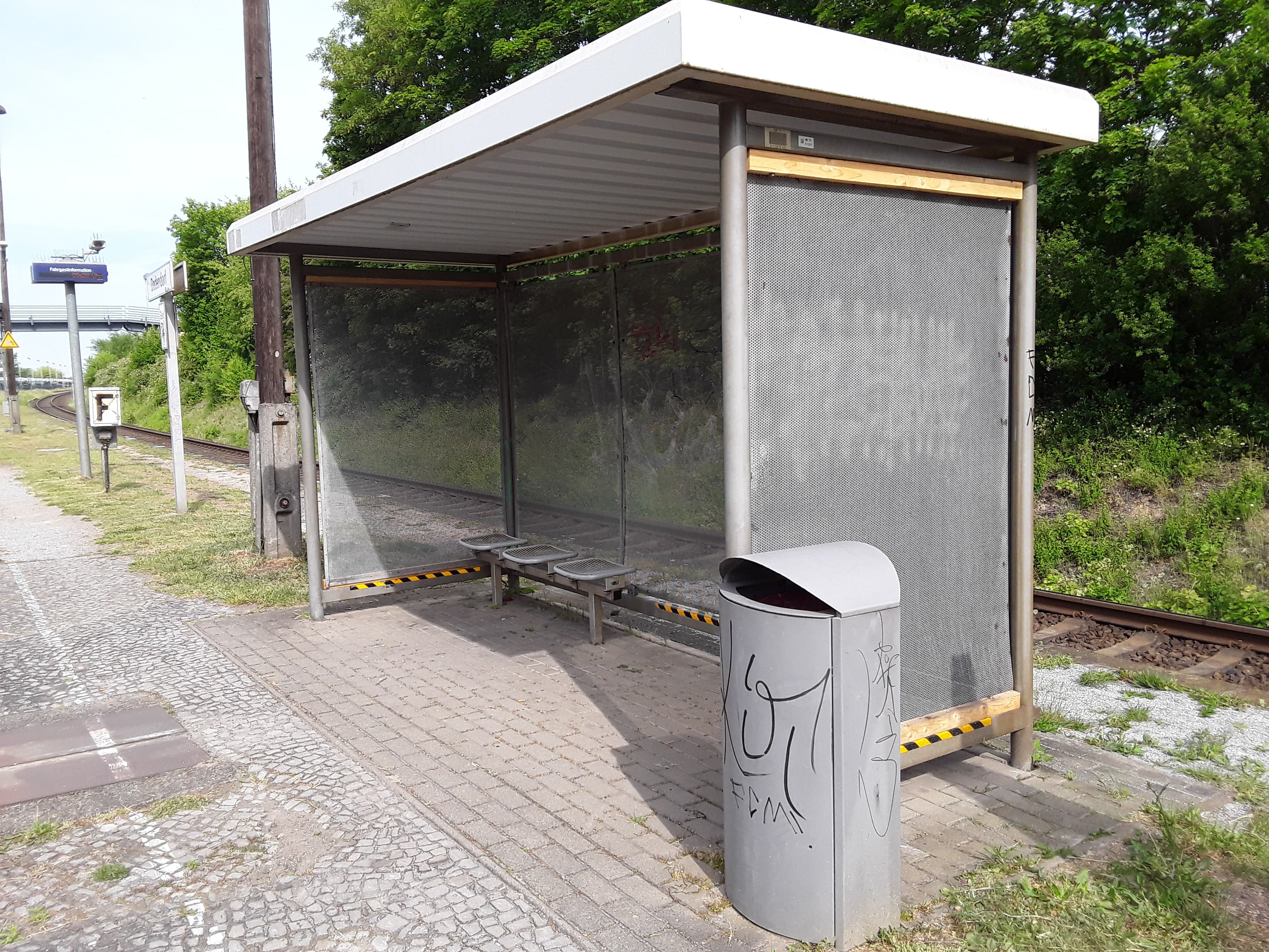 Vorherbild der Ausstattung: Vandaliertes, altes WSH mit Lochblechen, Drahtgitterbänken und ein nicht sanierter Bahnsteig