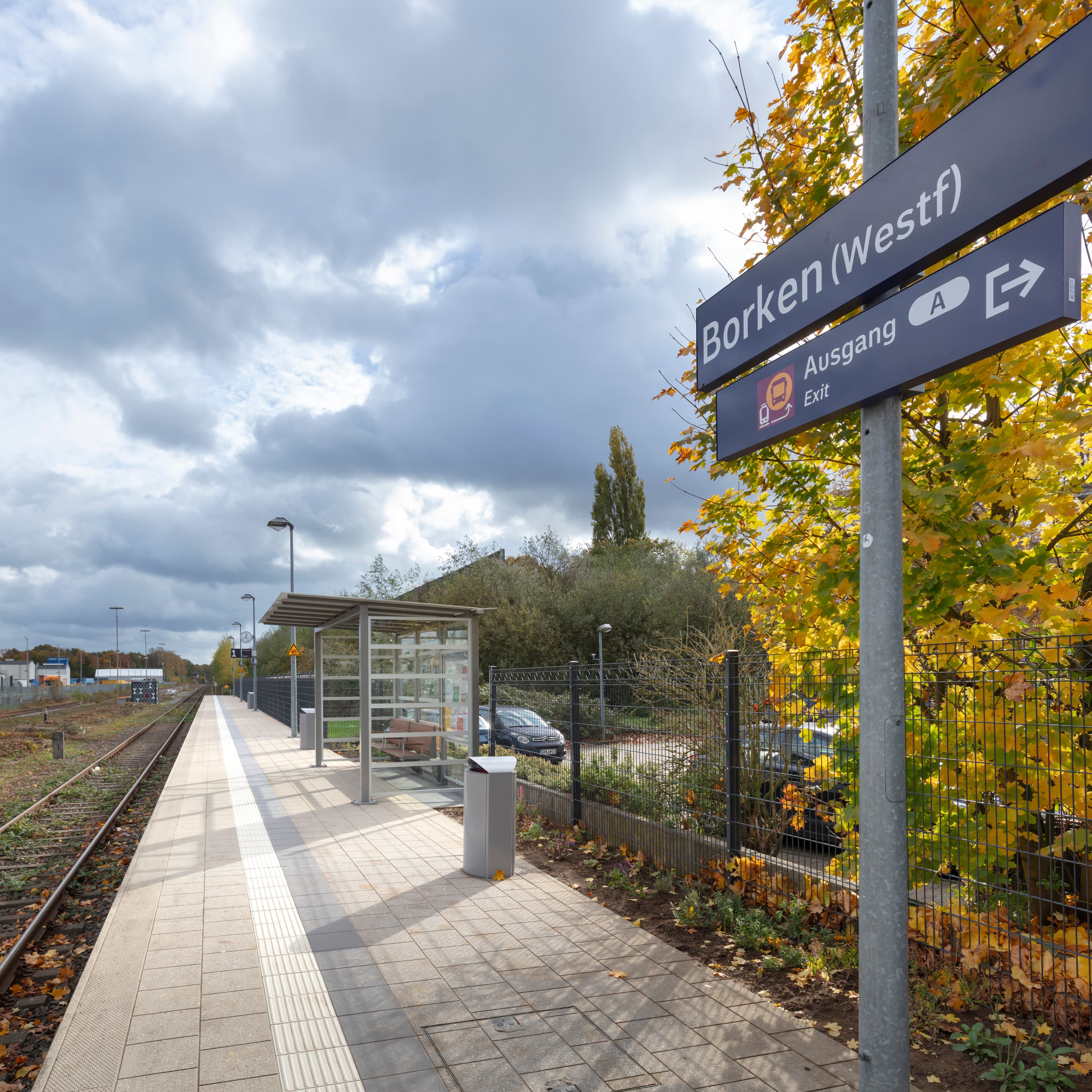 Blick auf eines der neuen lichtdurchlässigen Wetterschutzhäuschen mit modernen Sitzmöbeln aus Bambus am Bahnsteig.