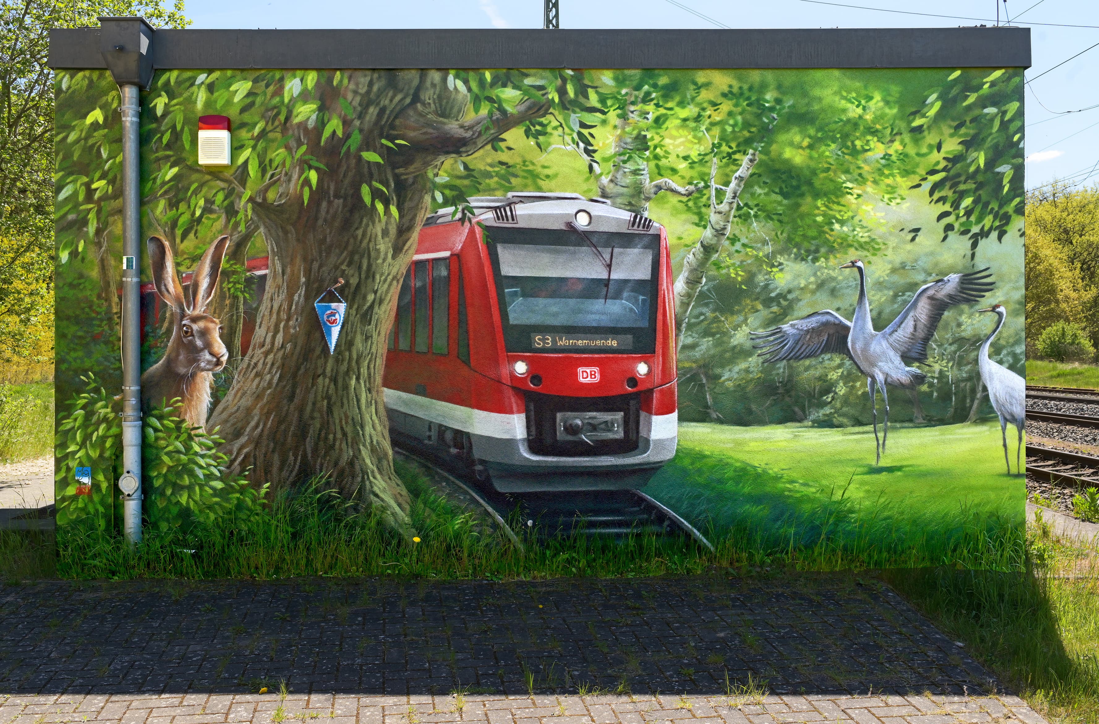 Eine bunt gestaltete Wand mit einer Regionalbahn.