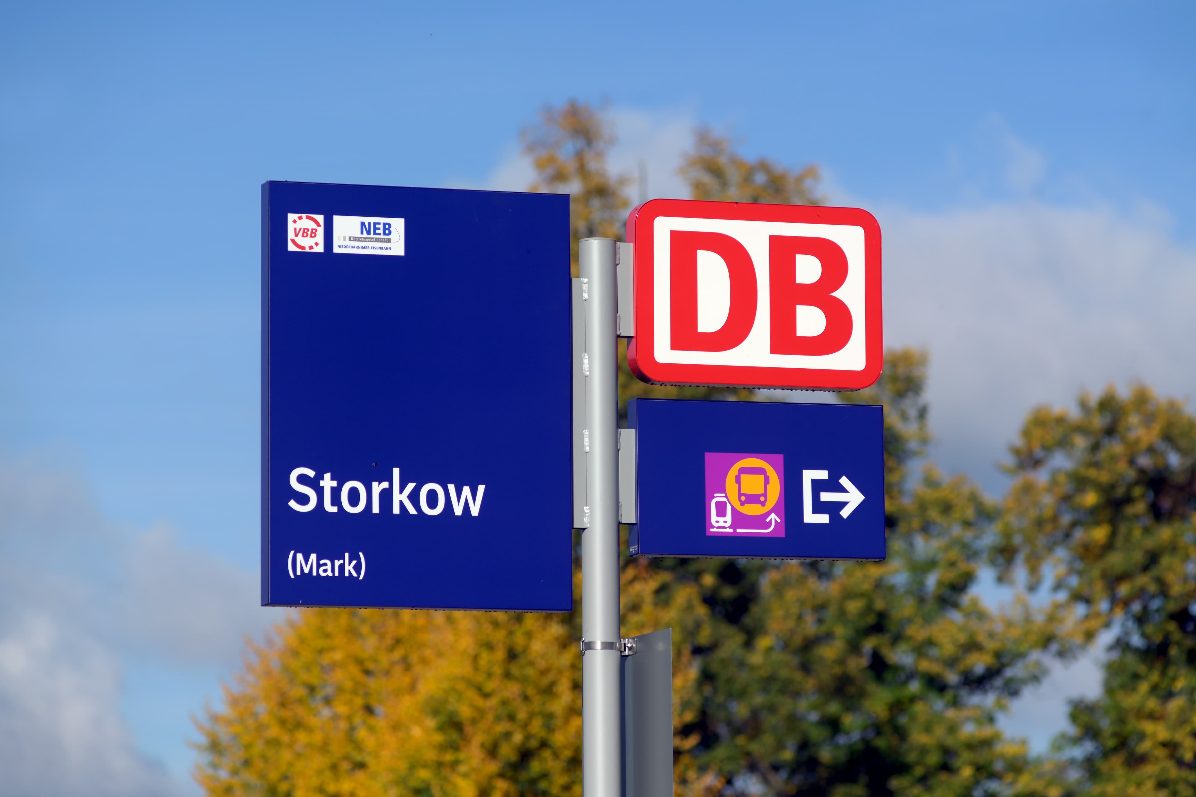 Ein Bahnhofsschild "Storkow" und ein DB -Logo.