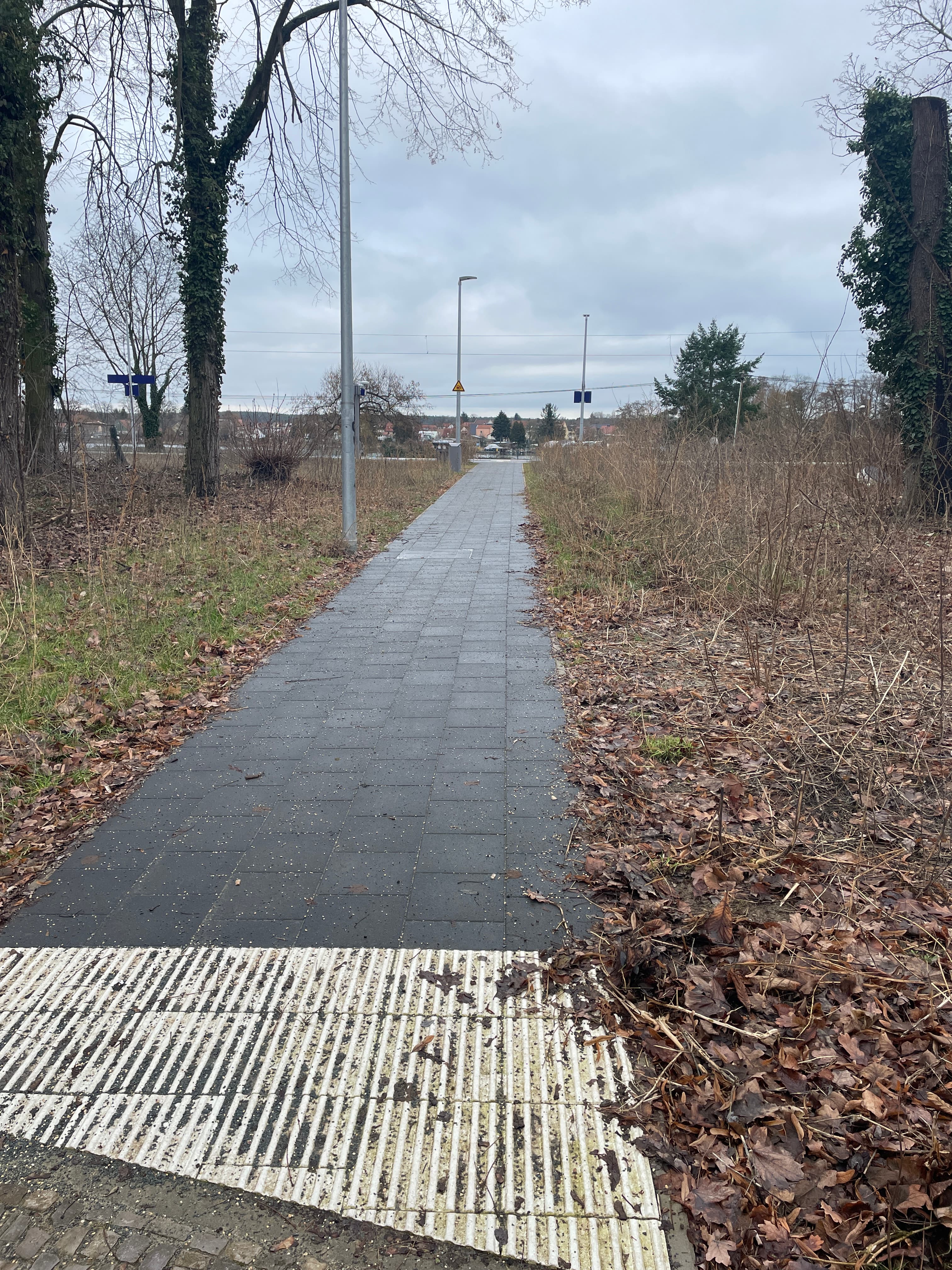 Ein gepflasterter Weg, der zu einem Bahnsteig führt.