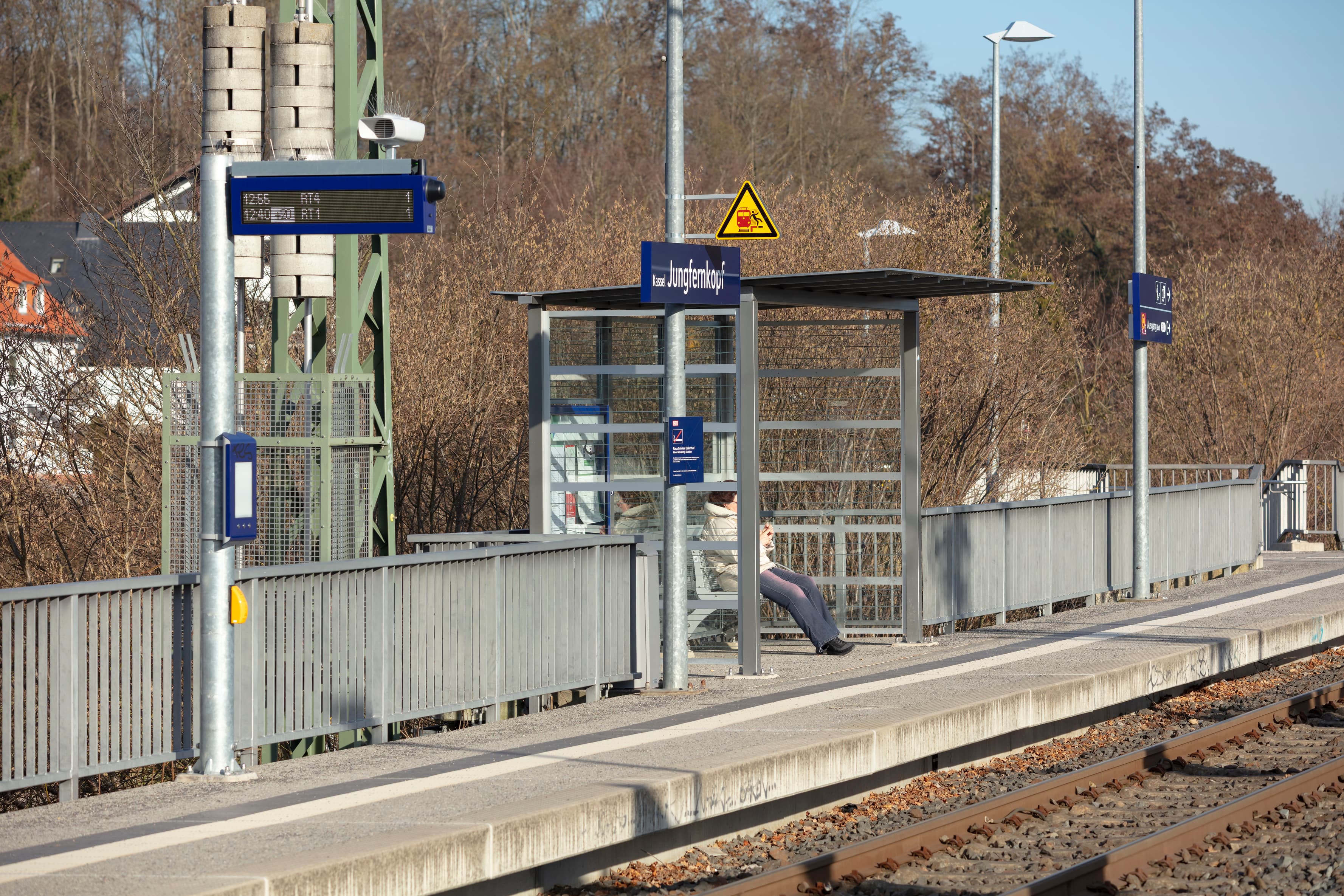 Blick auf einen Bahnsteig mit Wetterschutzhäuschen und links davon neue Wegweiser.