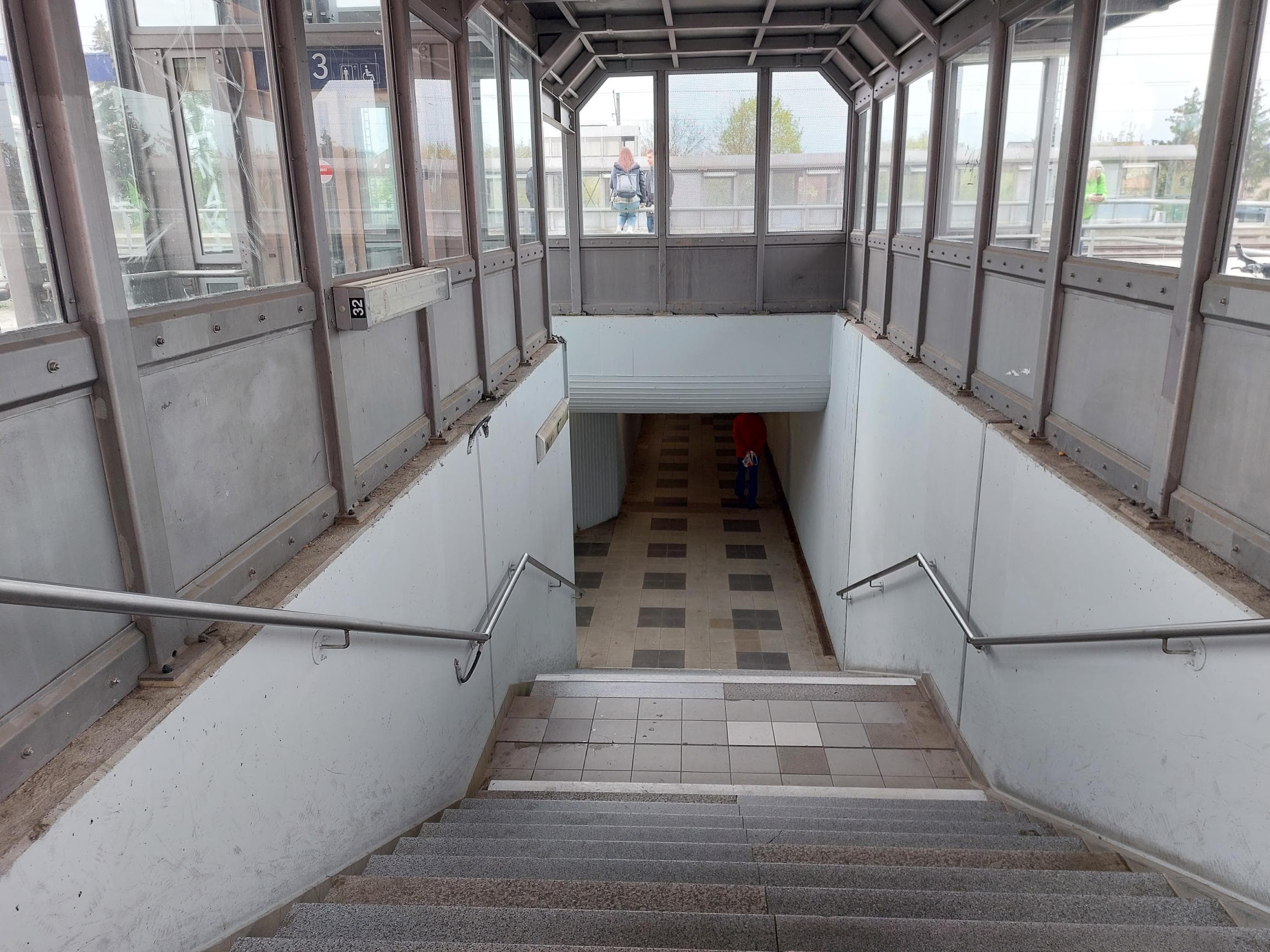 Ein Treppenaufgang mit weißen Wänden und grauen Blech-Einsätzen.