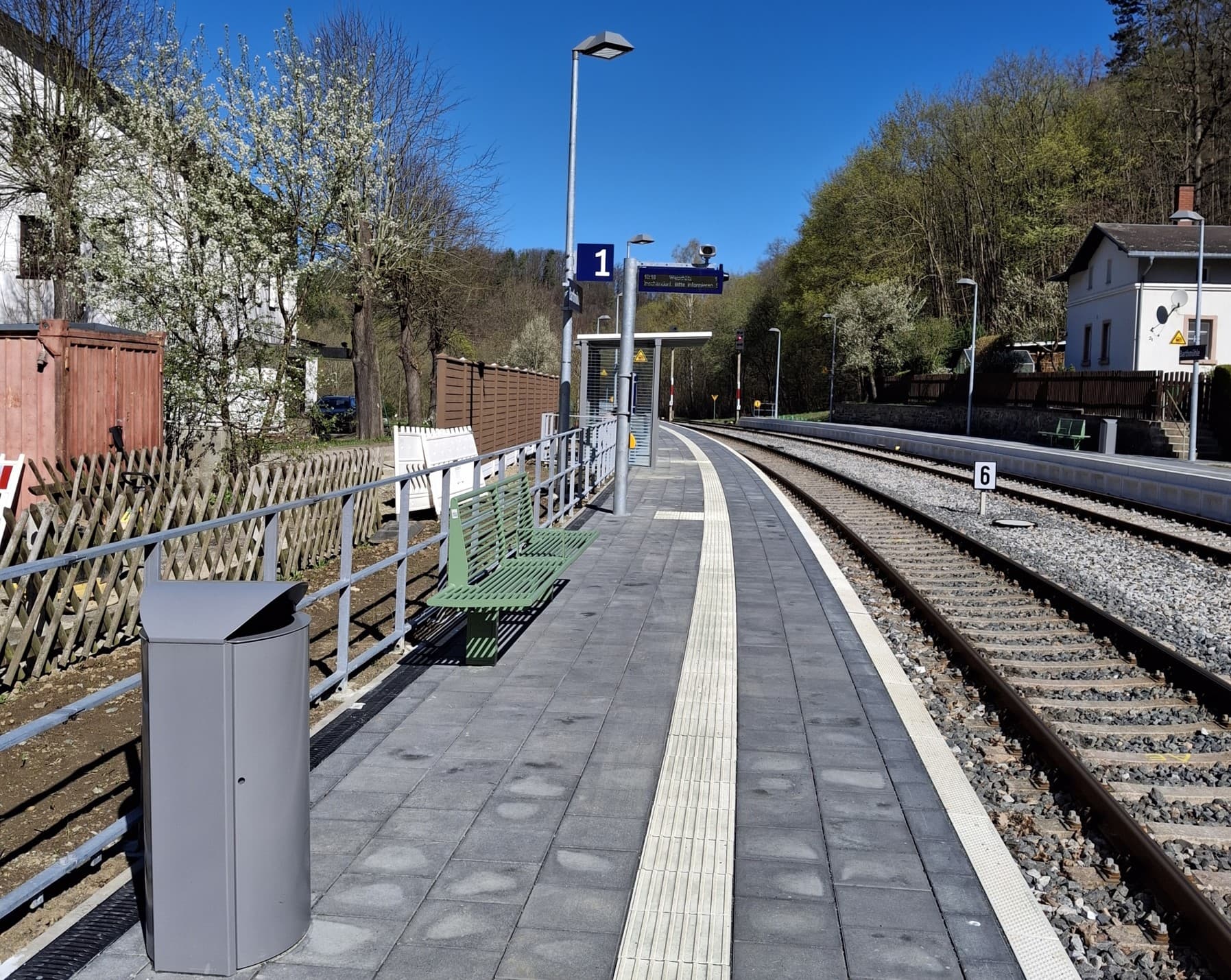 Der neue, erhöhte Bahnsteig mit neuen, grünen Sitzbänken.