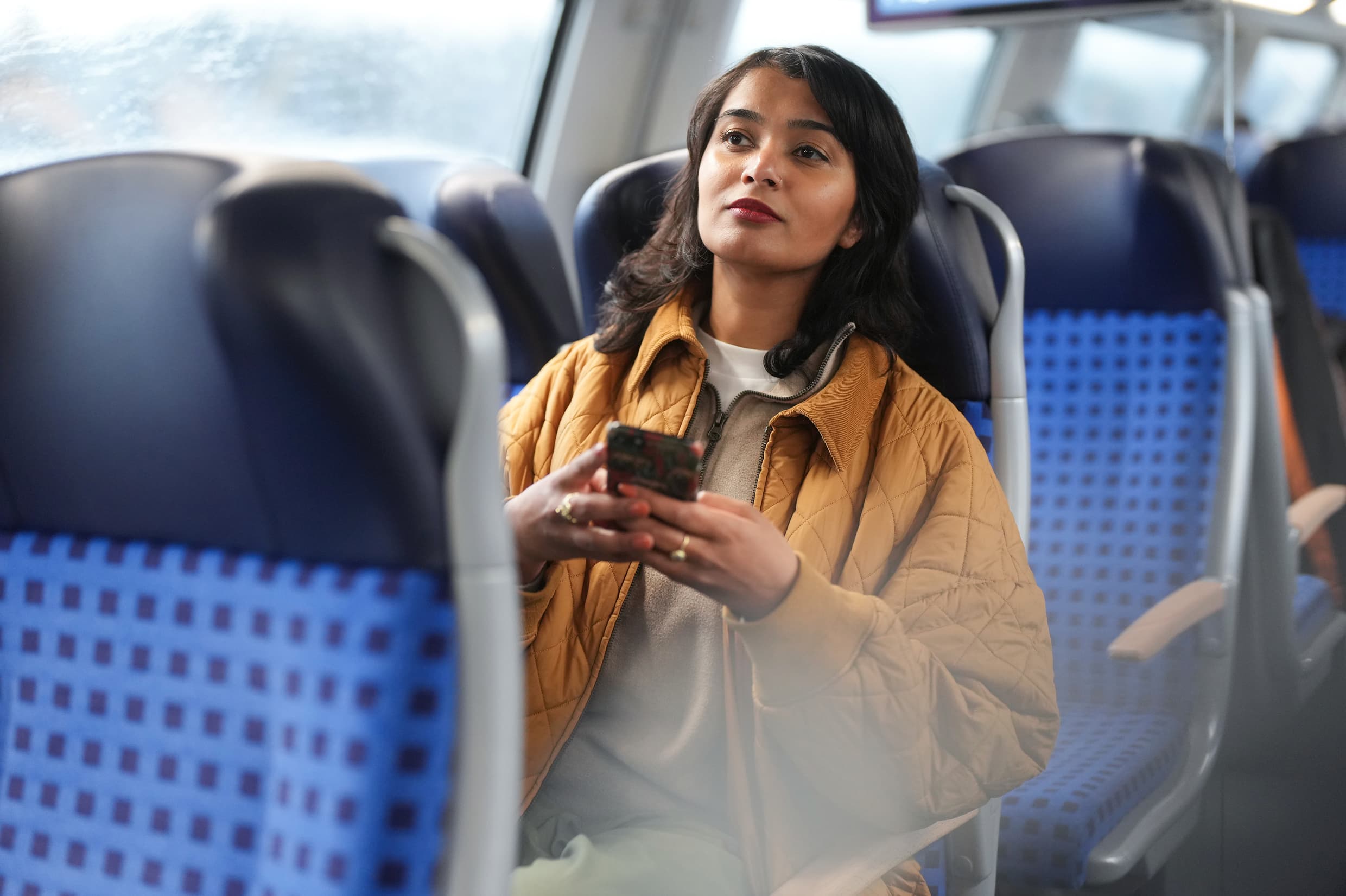 Reisende mit Smartphone im Regionalzug.