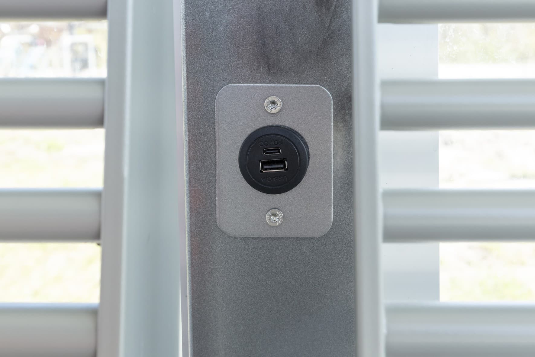 Detailaufnahme einer USB-Ladebüchse am Bahnsteig.
