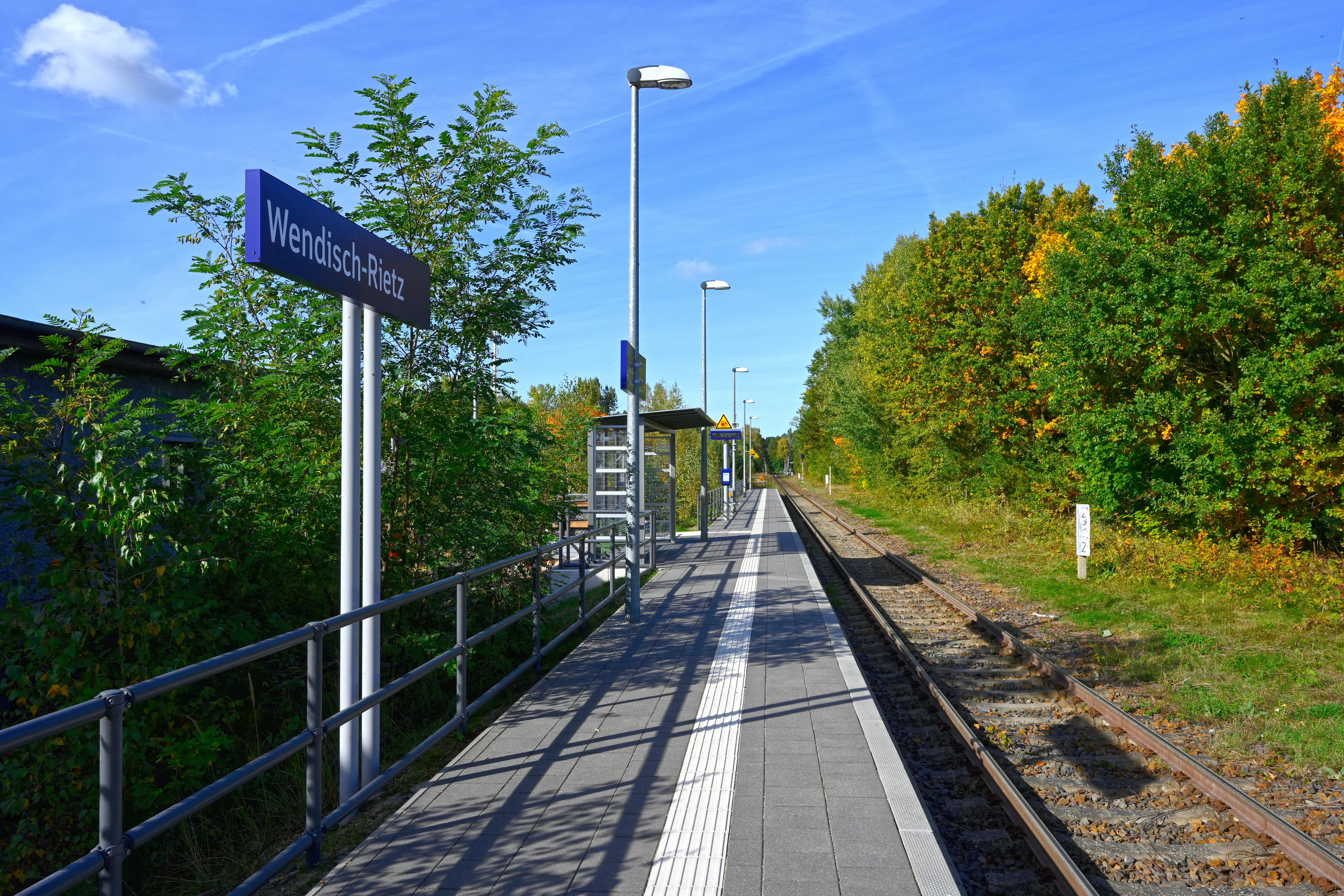 Ein Bahnsteig mit Bahnhofsschild links, ein Gleis rechts.