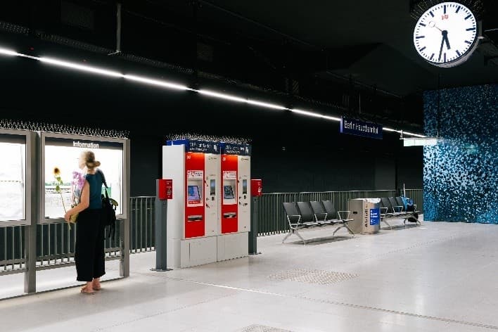 S15-Bahnsteig mit Informationsvitrinen, Sitzgelegenheiten und Wandgestaltung.