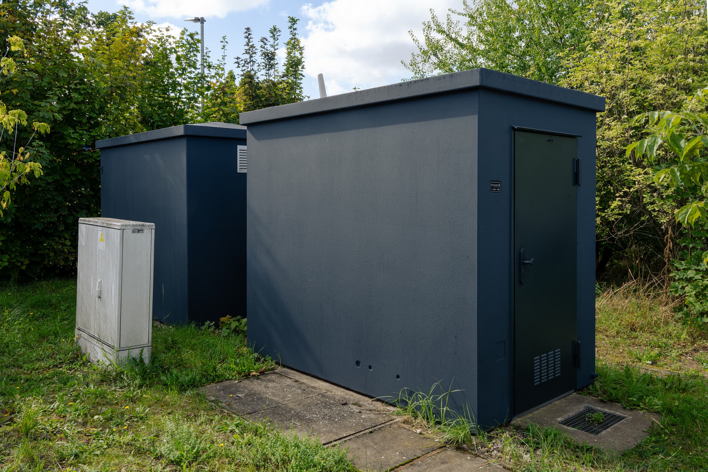 Zwei grau angestrichene Trafohäuser