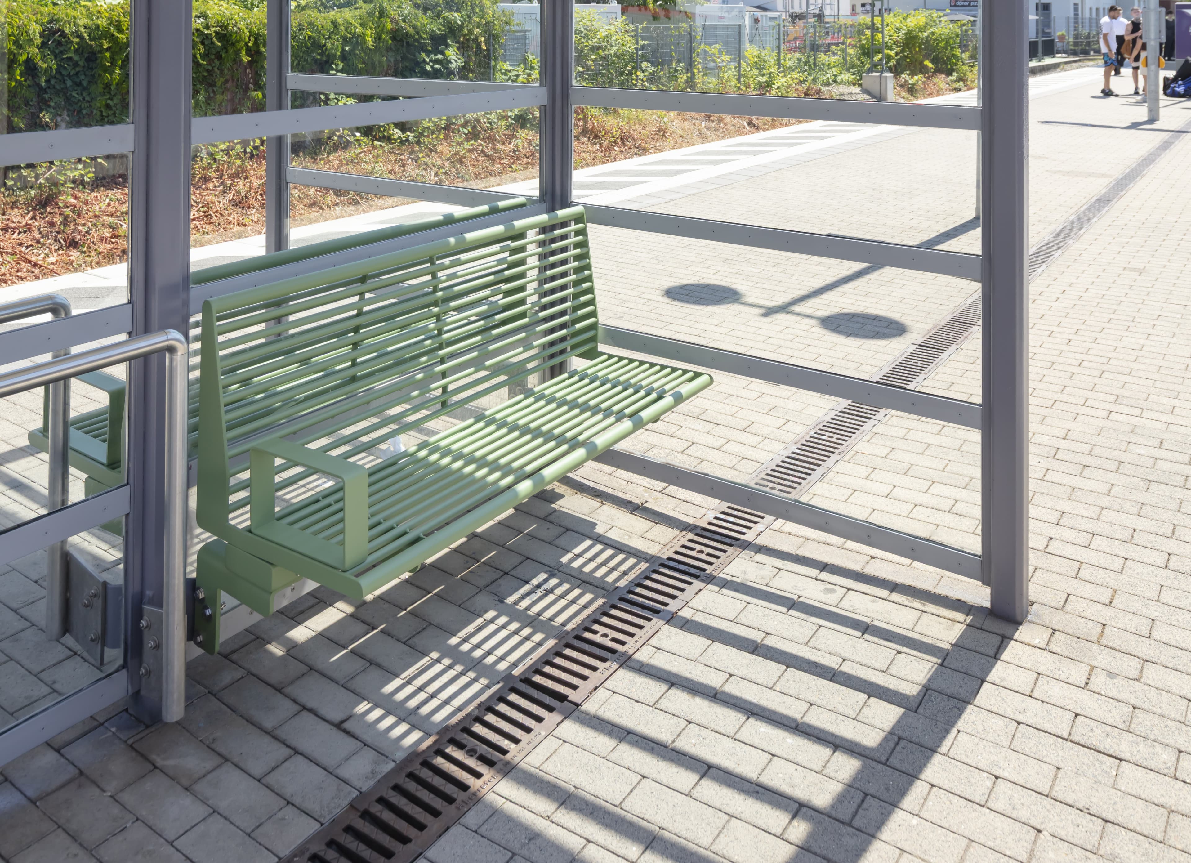 Detailaufnahme der neuen grünen Sitzbank im Wetterschutzhäuschen.