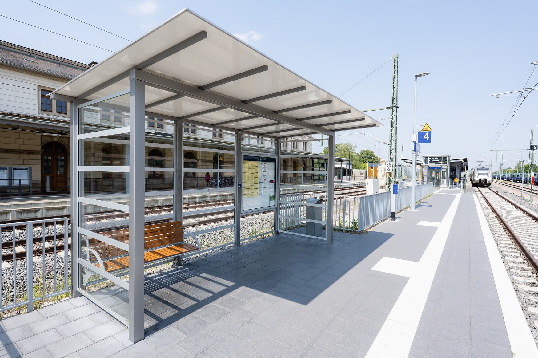 Ein volltransparentes Wetterschutzhaus mit einer neuen Bank.