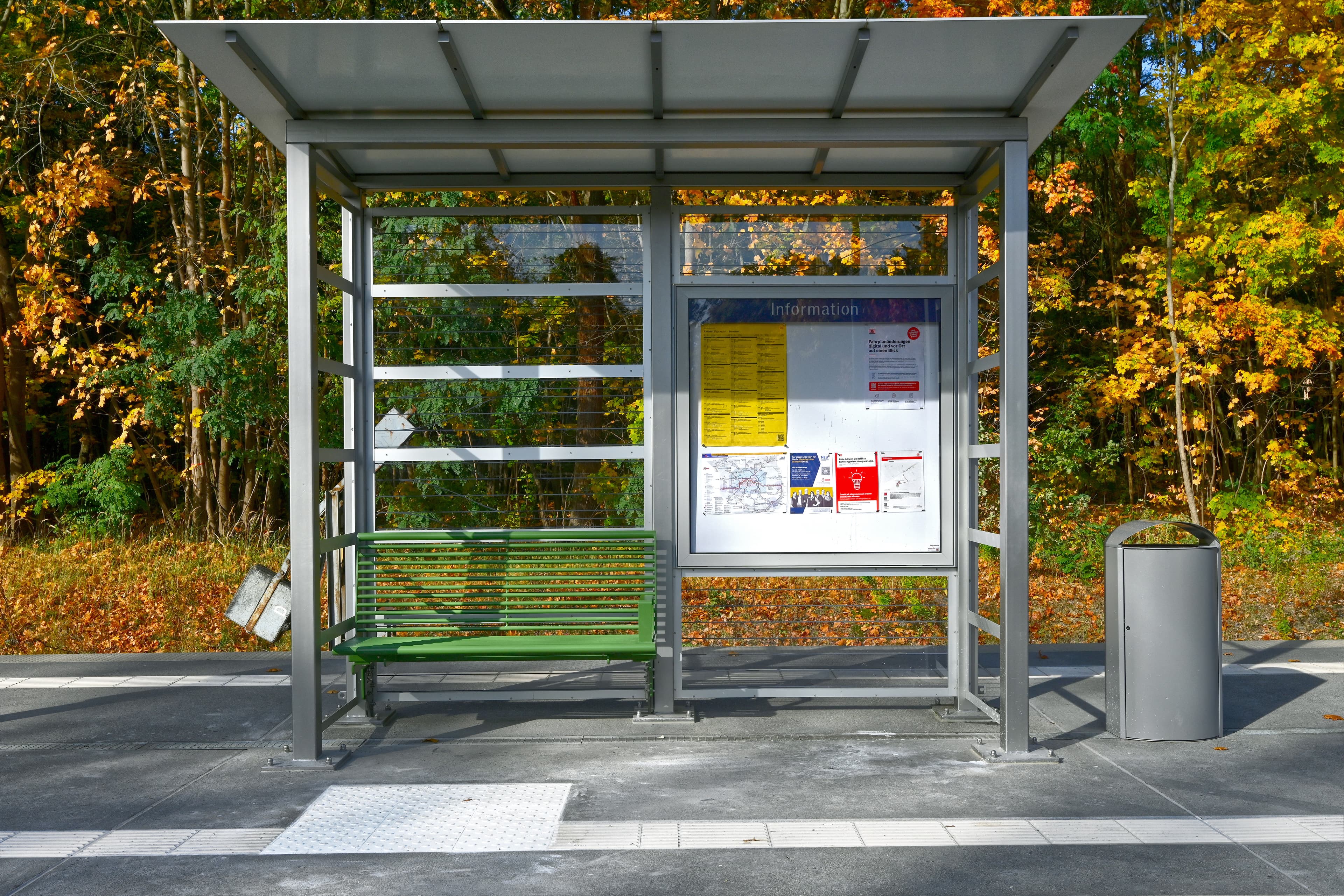 Blick auf ein Wartehaus mit grüner Sitzbank.