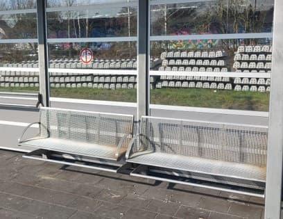 Im Bild eine angerostete Bank in einem Wetterschutzhäuschen