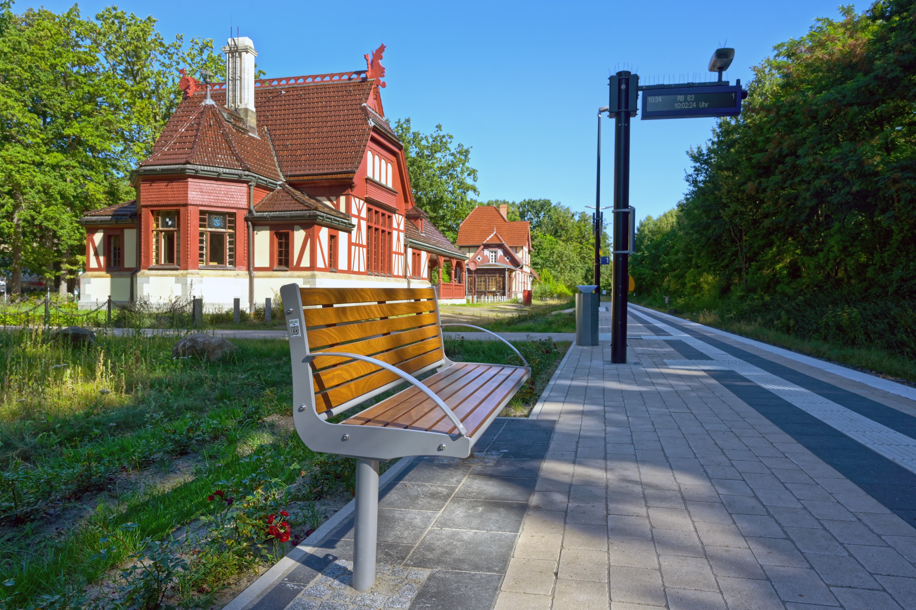 Blick auf eine Sitzbank vor einem Bahnhofsgebäude.
