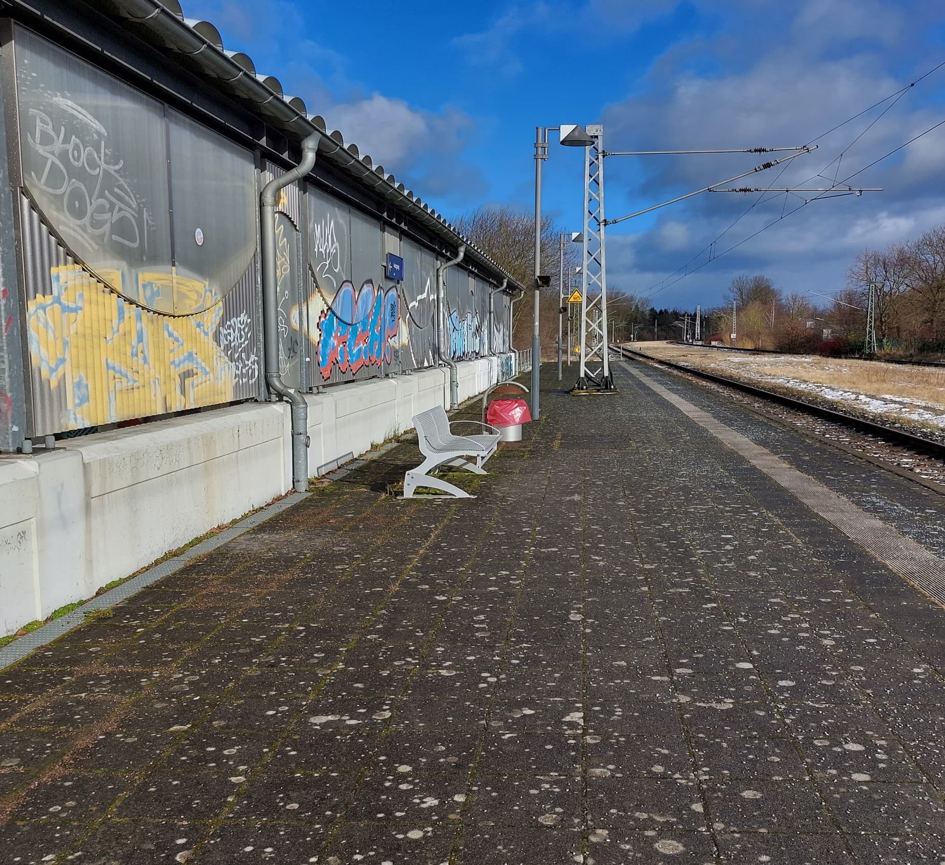 Blick über Bahnsteig 2 vor den ZKB-Maßnahmen. An der Wand zur Fahrradrampe sind viele Graffiti, der Boden ist voller Flechten und Kaugummiflecken. 