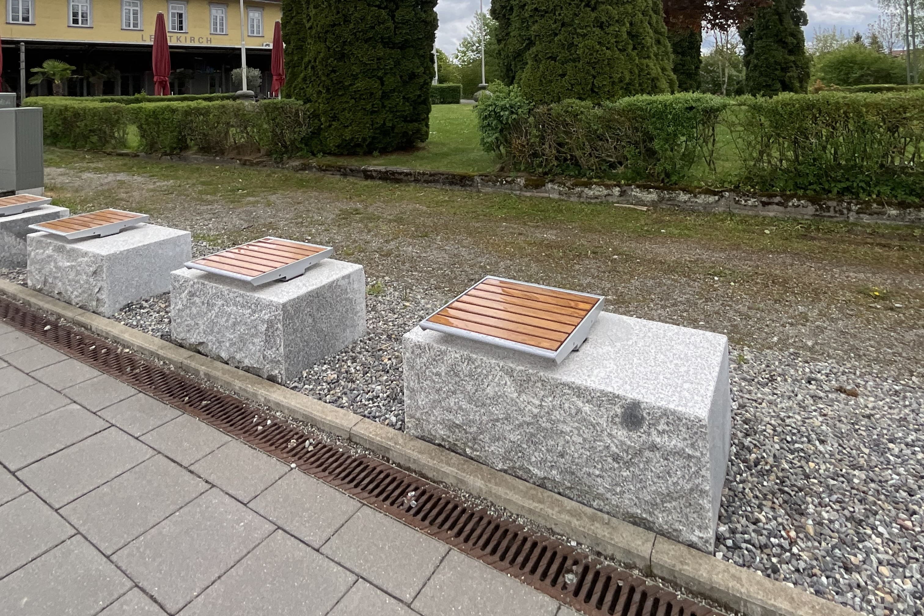Bahnsteig mit Granitsteinen und Einzelsitzen.