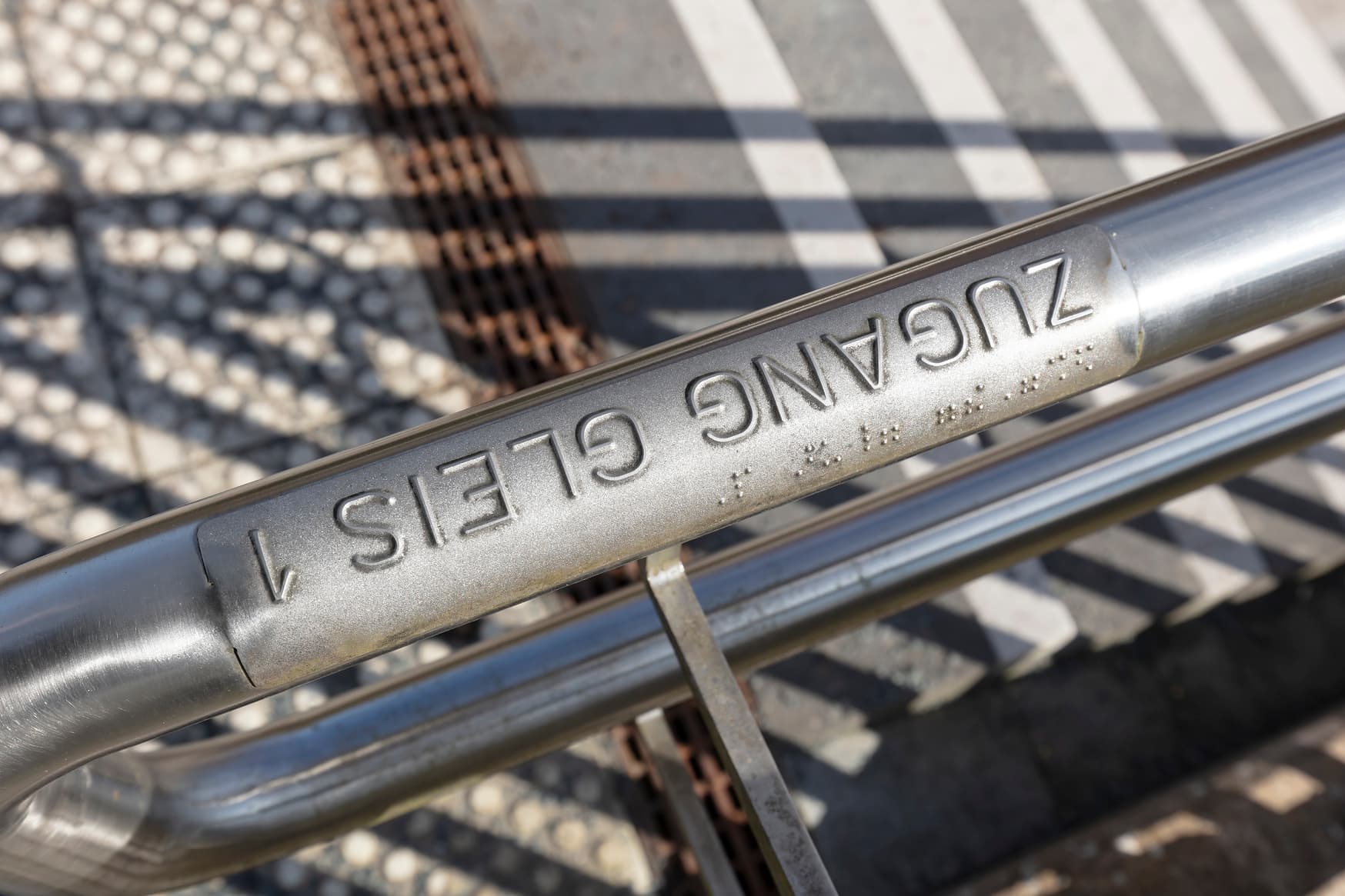 Detailaufnahme des Handlaufes mit Brailleschrift Gleis 1.