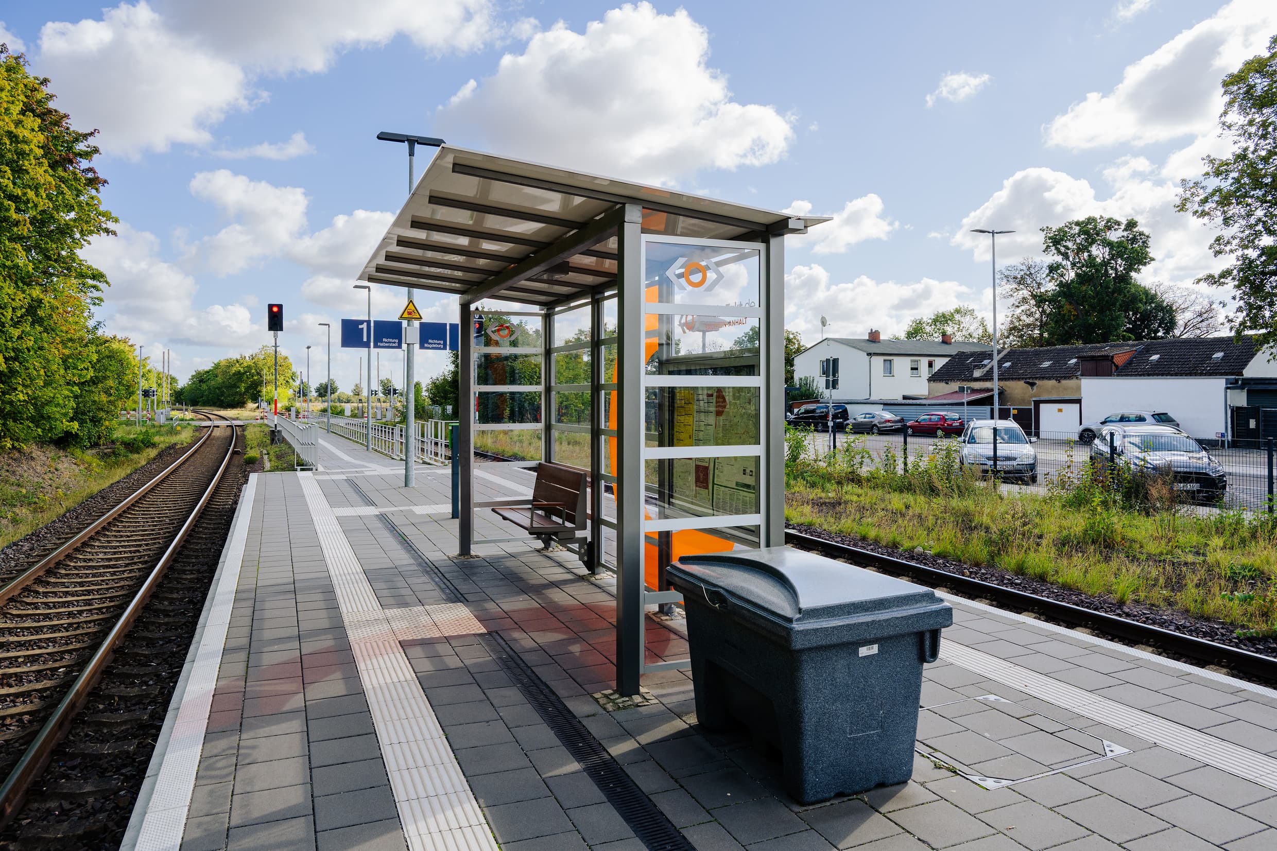 Das Wetterschutzhäuschen mit volltransaprenten Scheiben inklusive einer dezenten Gestaltung auf dem Bahnsteig. Darin eine hochwertige Bambusbank und eine Infovirtrine. 