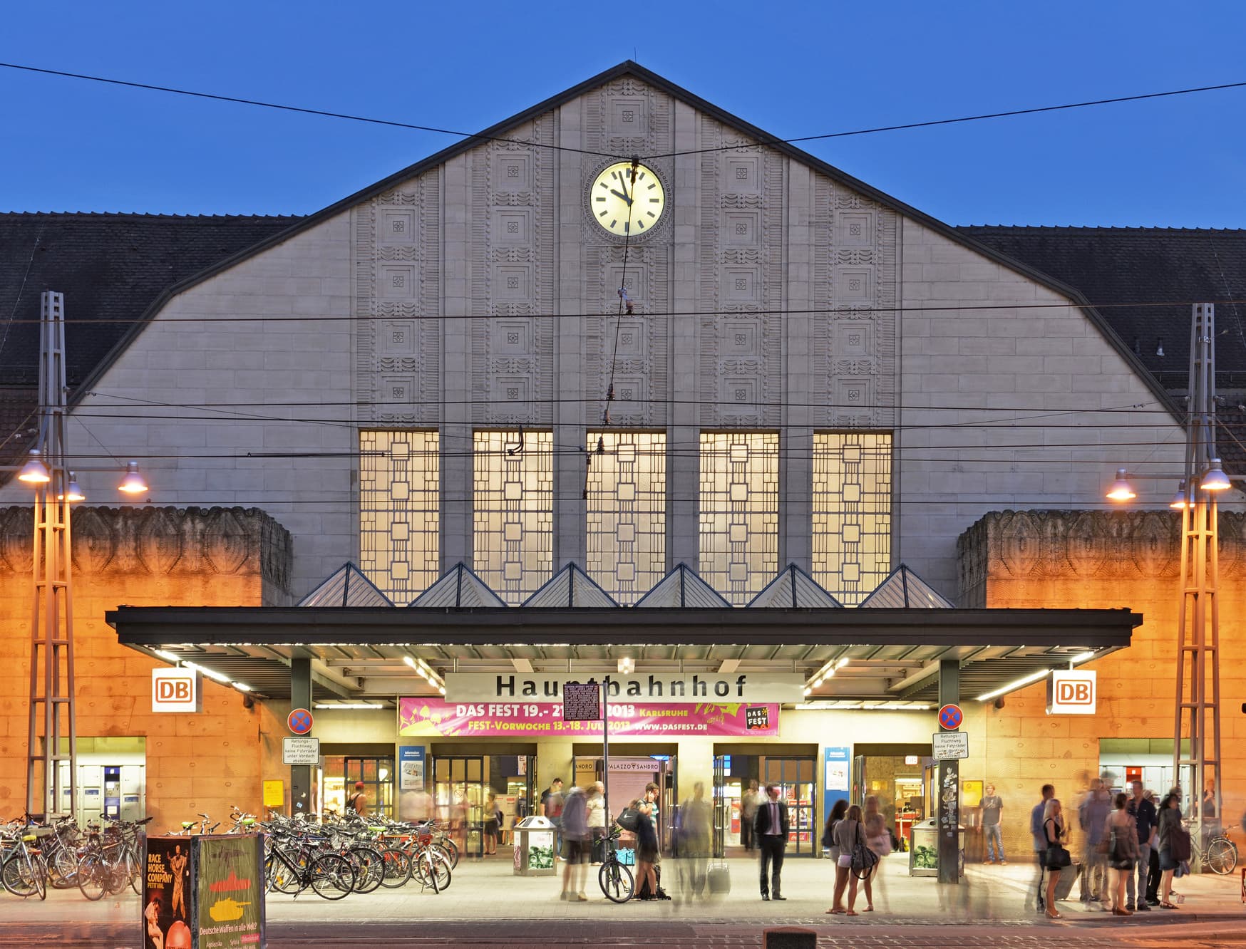 Empfangsgebäude des Karlsruher Hauptbahnhofs bei Nacht.