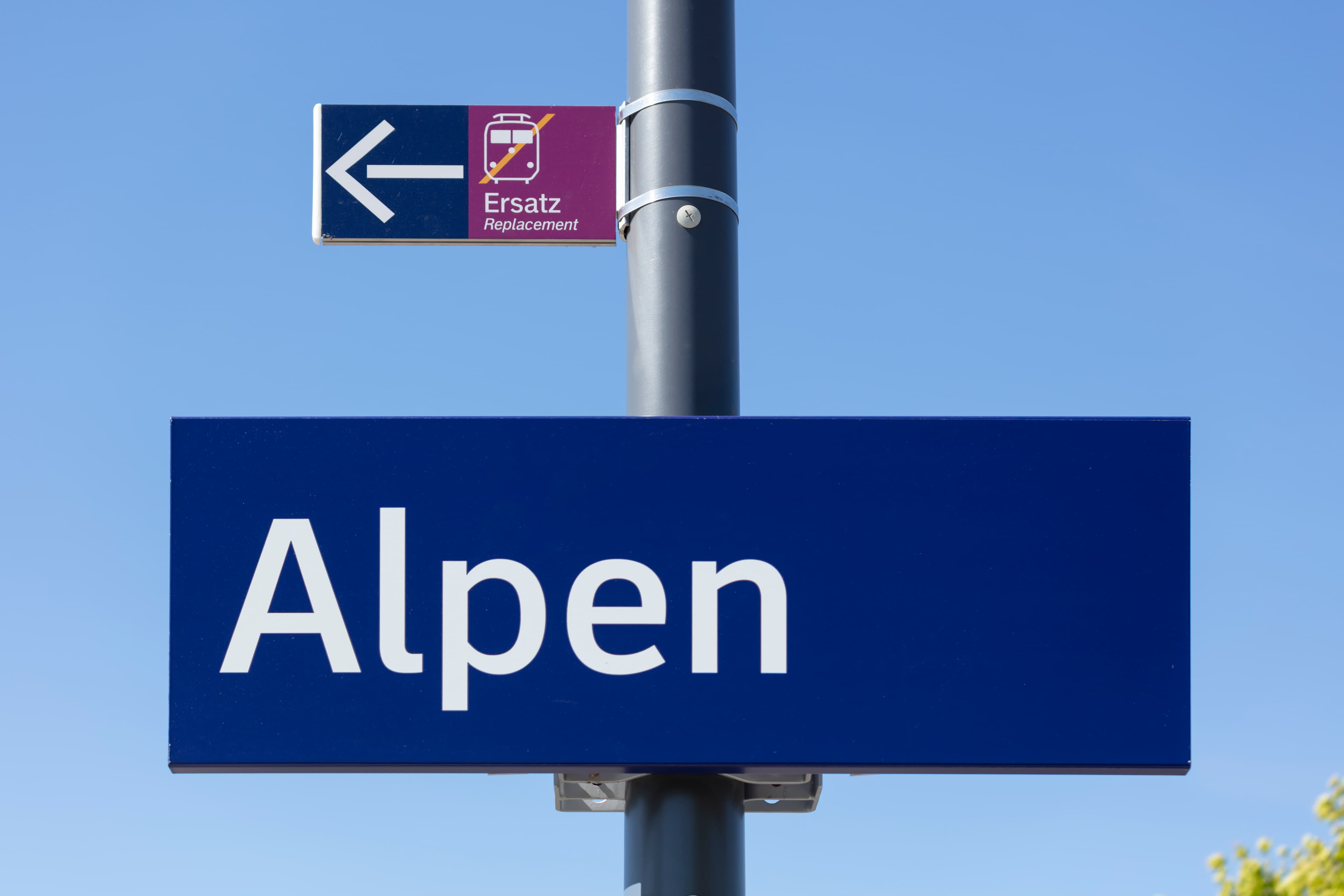 Blaue Beschilderung mit weißer Aufschrift "Alpen".