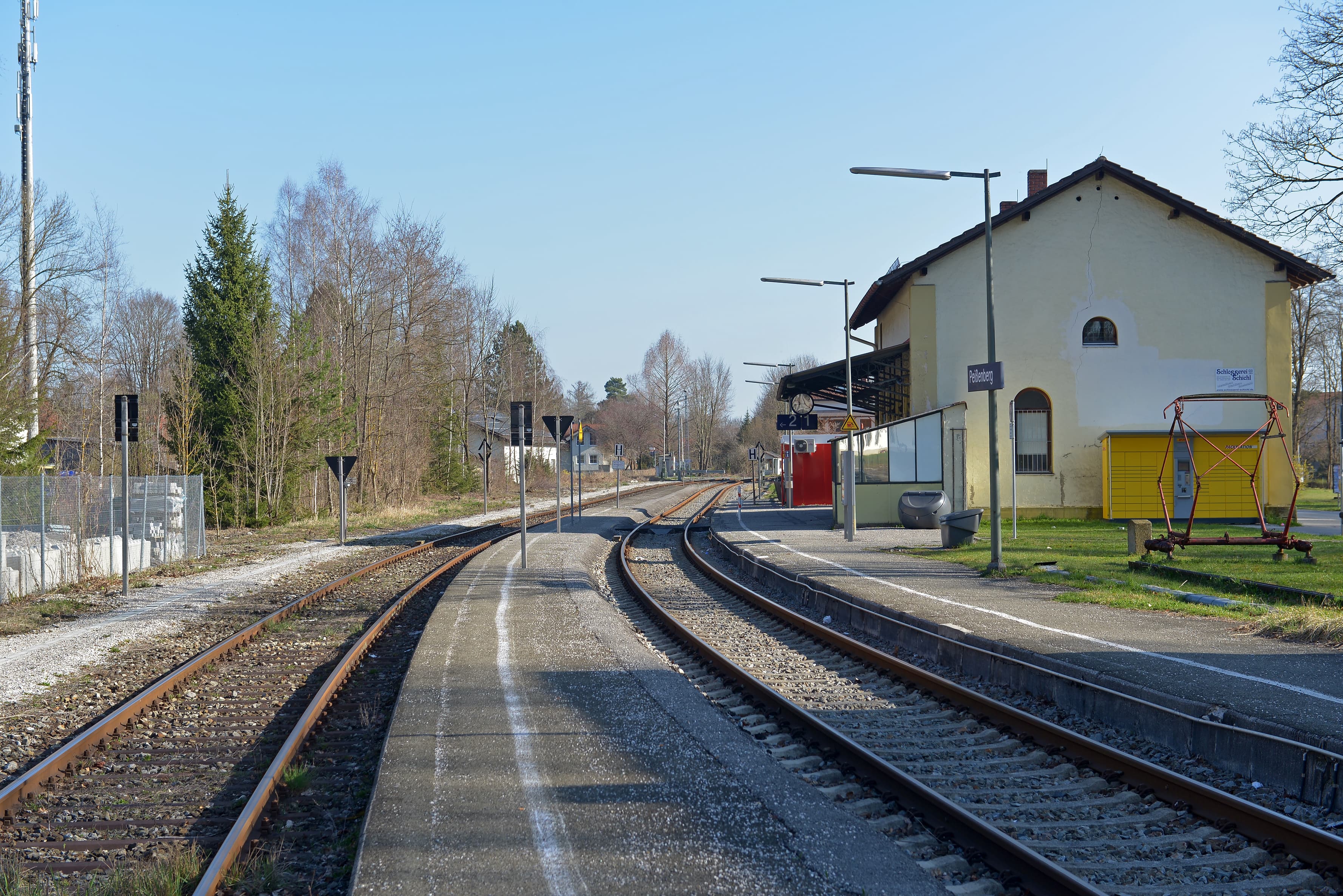 Abgebildet ein alter Bahnsteig. Links und rechts jeweils ein Gleis. Rechts im Hintergrund ein altes Gebäude.