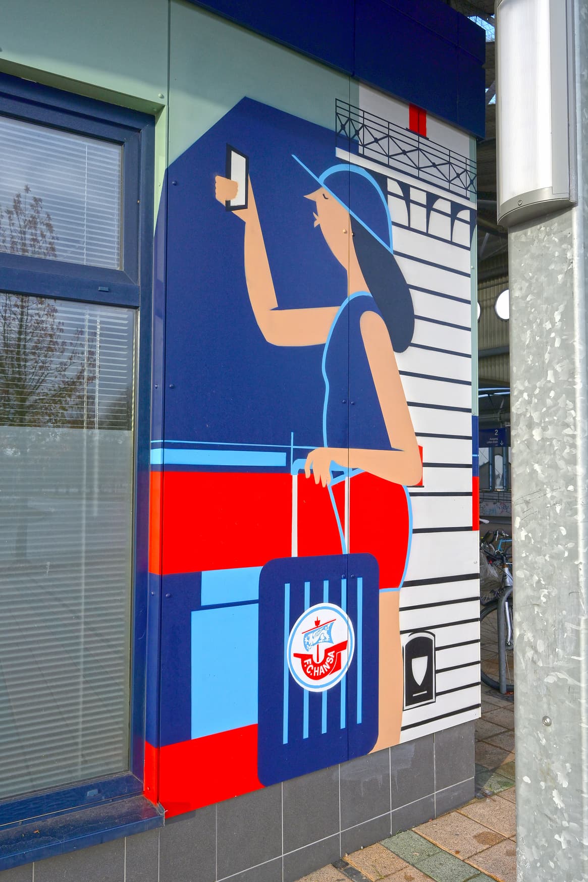 Gemalte Person in Comicstil mit Rollkoffer mit Hansa Rostock Wappen fotografiert mit dem Smartphone.