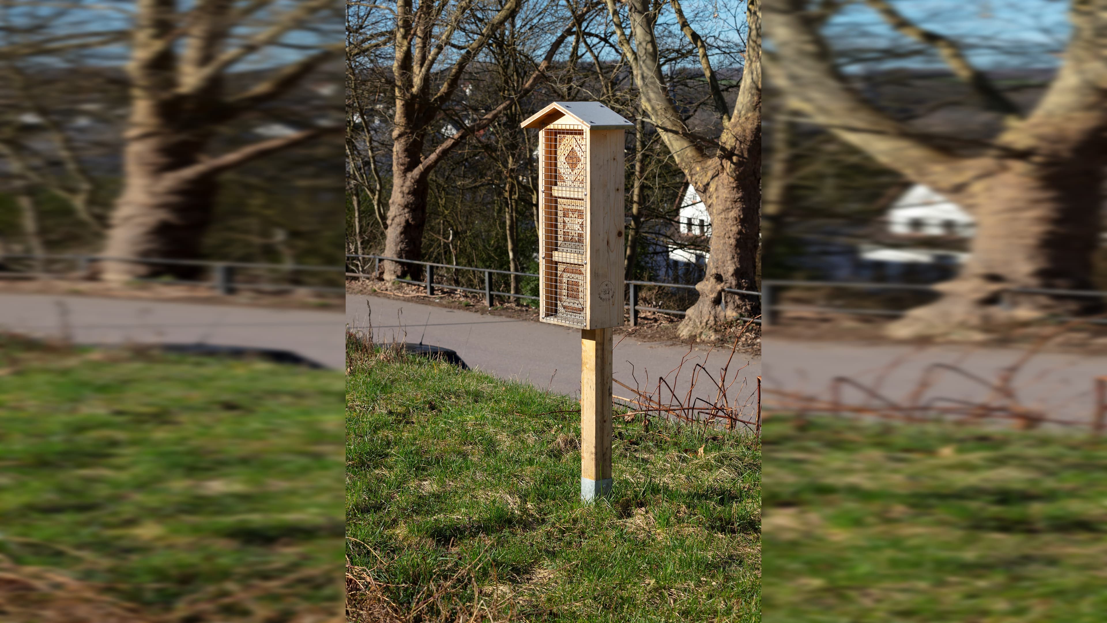 Blick auf ein Bienenhotel auf einer grünen Wiese.