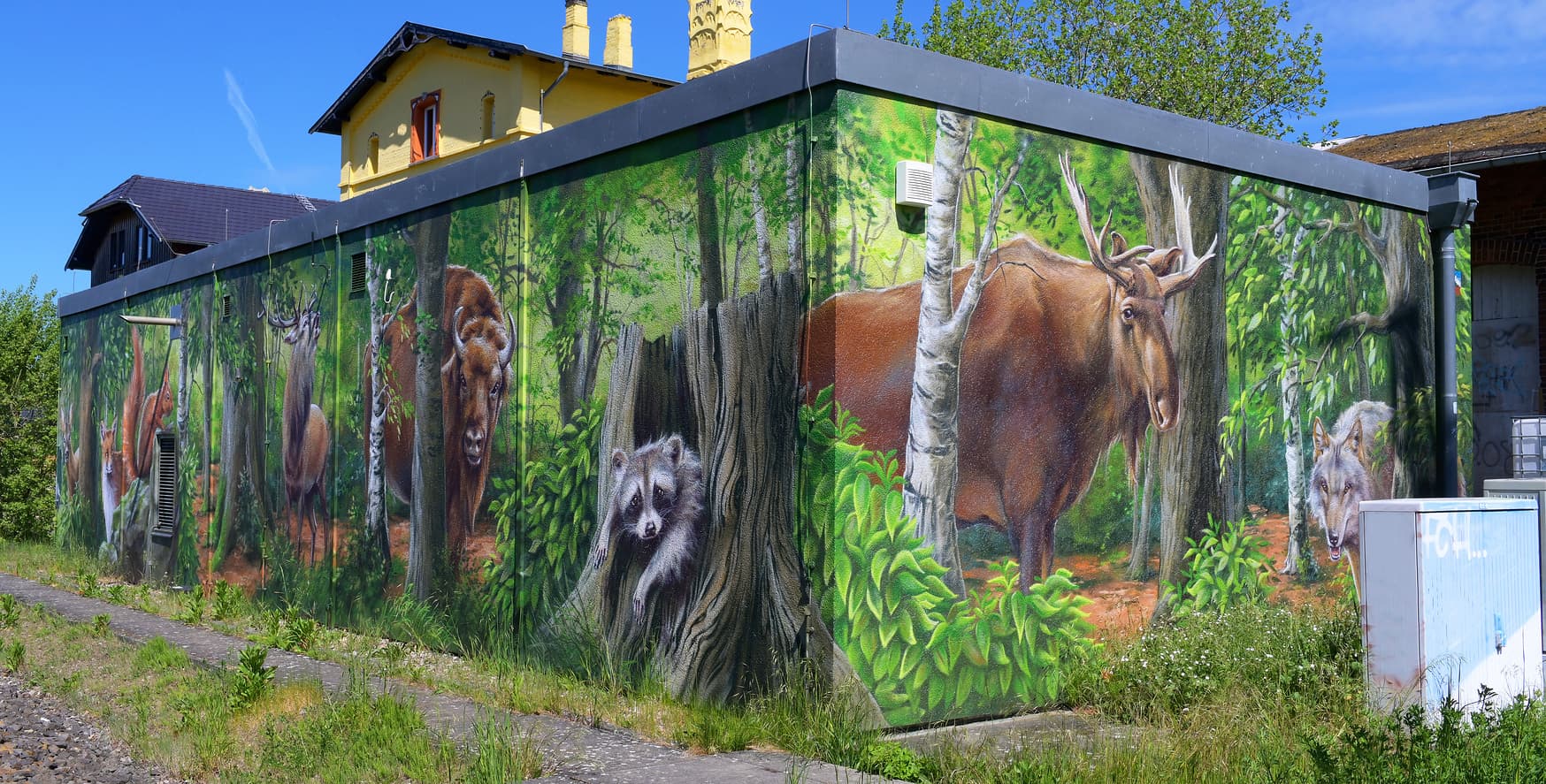 Gemalte Waldtiere auf der Fassade eines Häuschen.