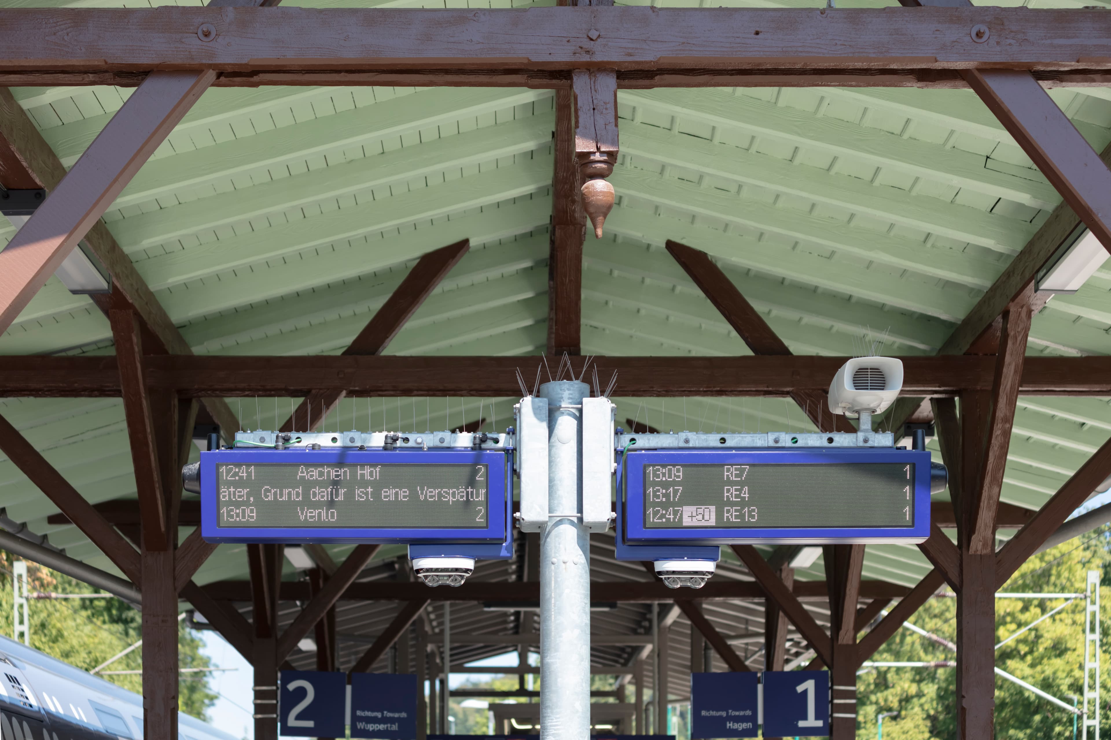Dynamische Schriftenanzeiger dreizeilig vor dem historischen Bahnsteigdach.