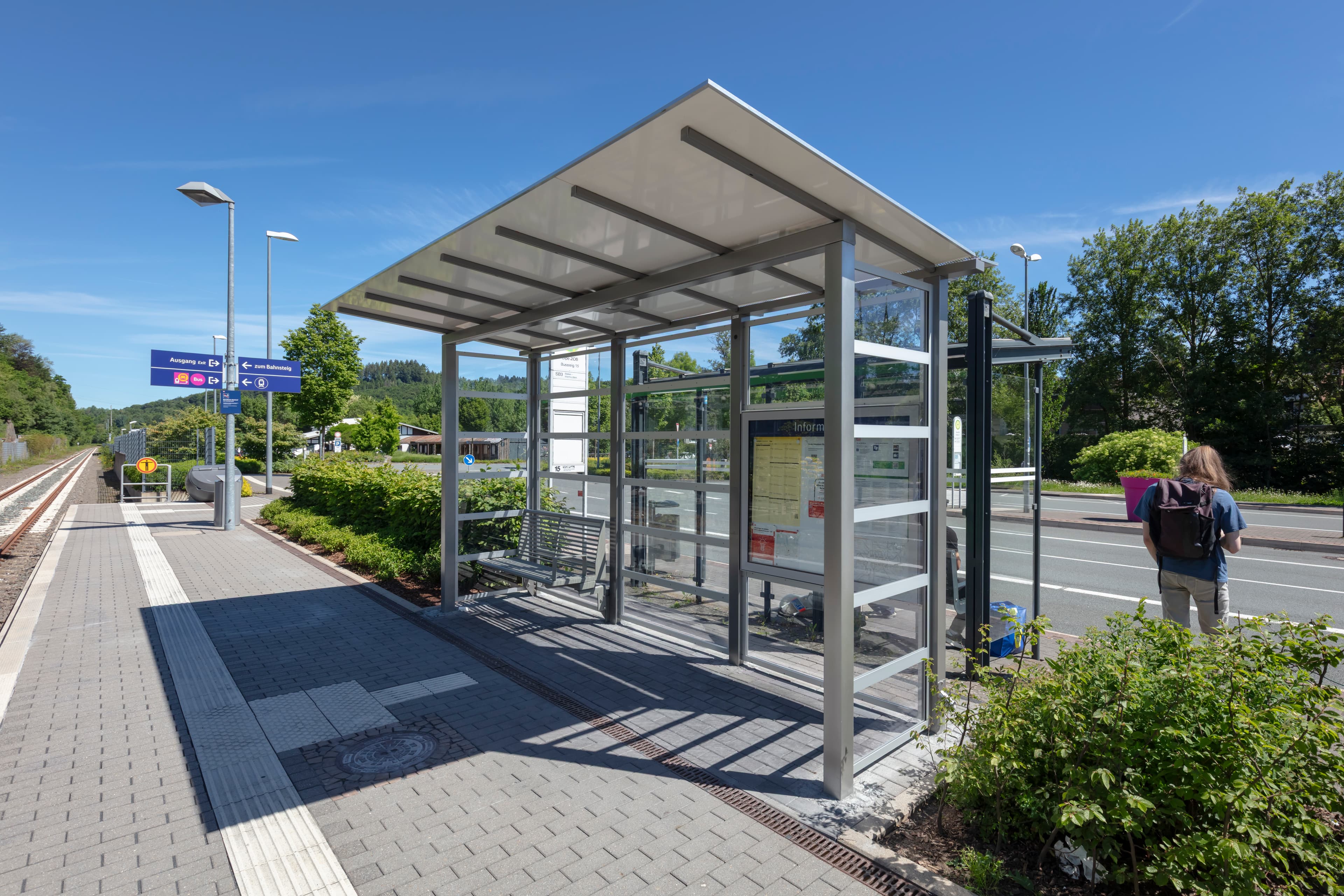 Blick auf das neue lichtdurchlässige Wetterschutzhäuschen mit komfortabler Sitzbank.