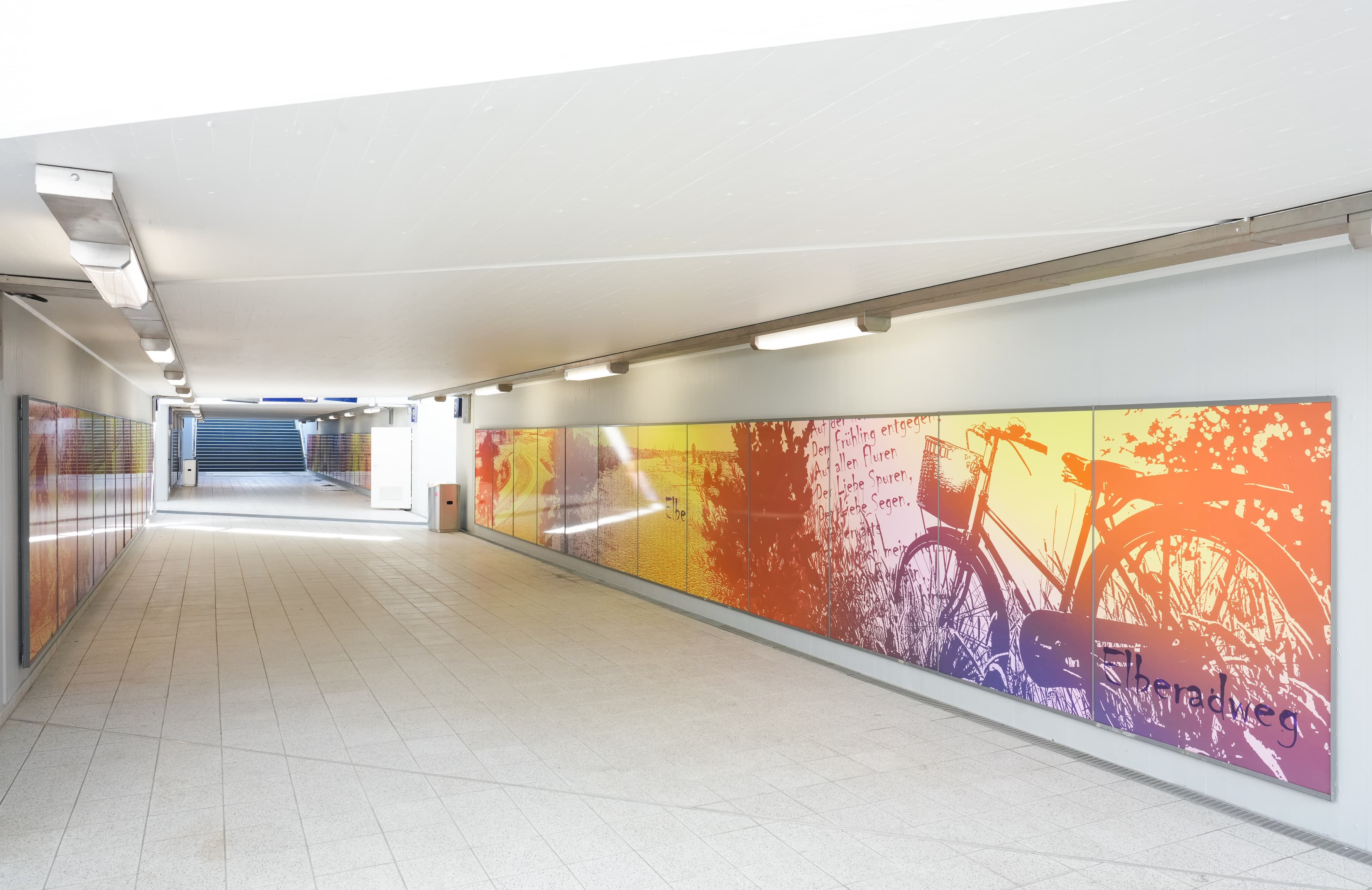 Bunte Wände in einem Personentunnel am Bahnhof.