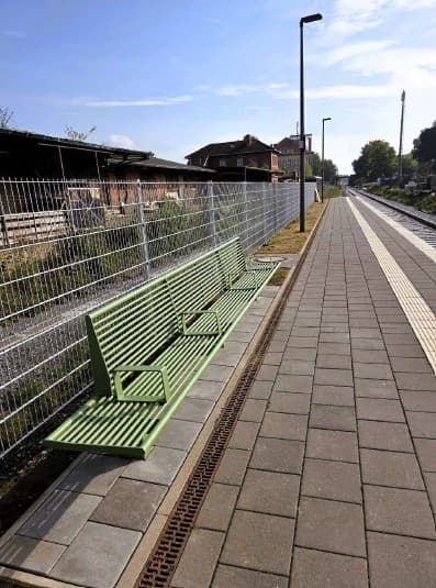 Eine lange Sitzbank erstreckt sich entlang des Bahnsteigs