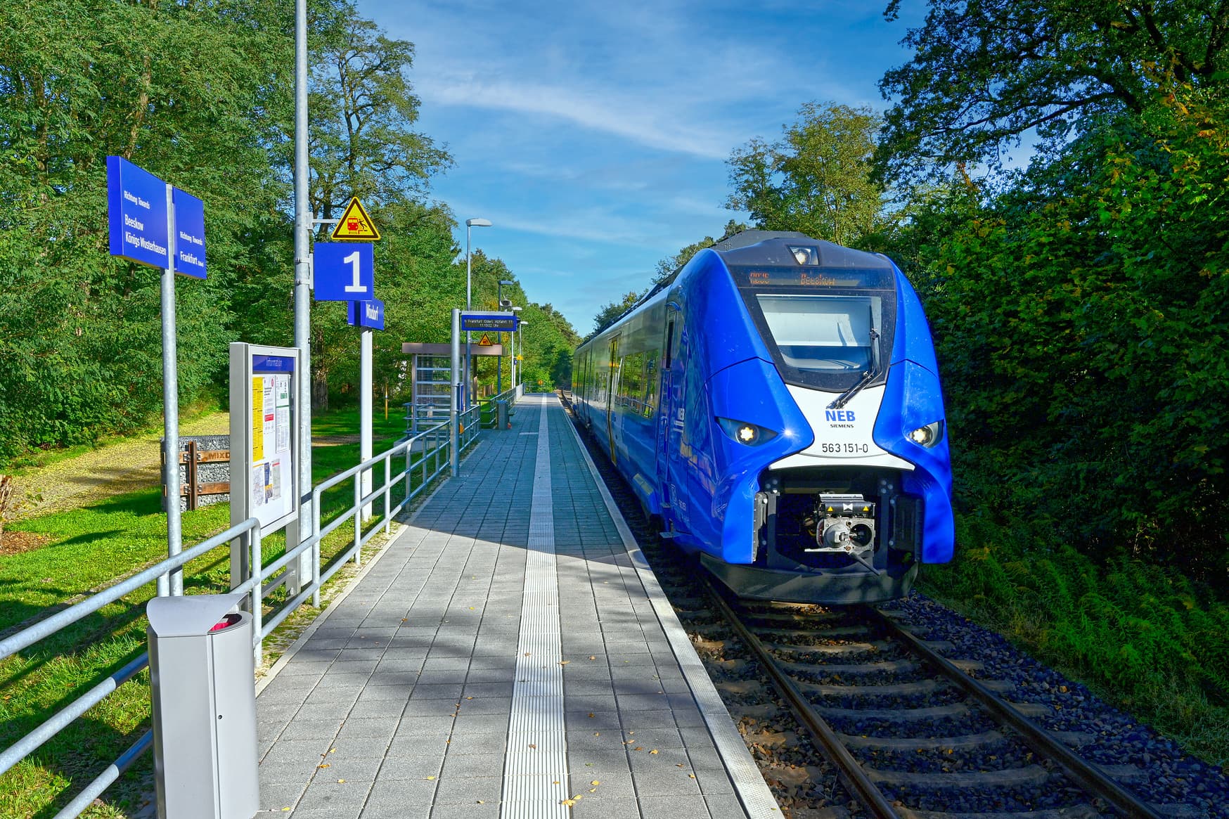 Ein haltender Zug der NEB am Bahnsteig.