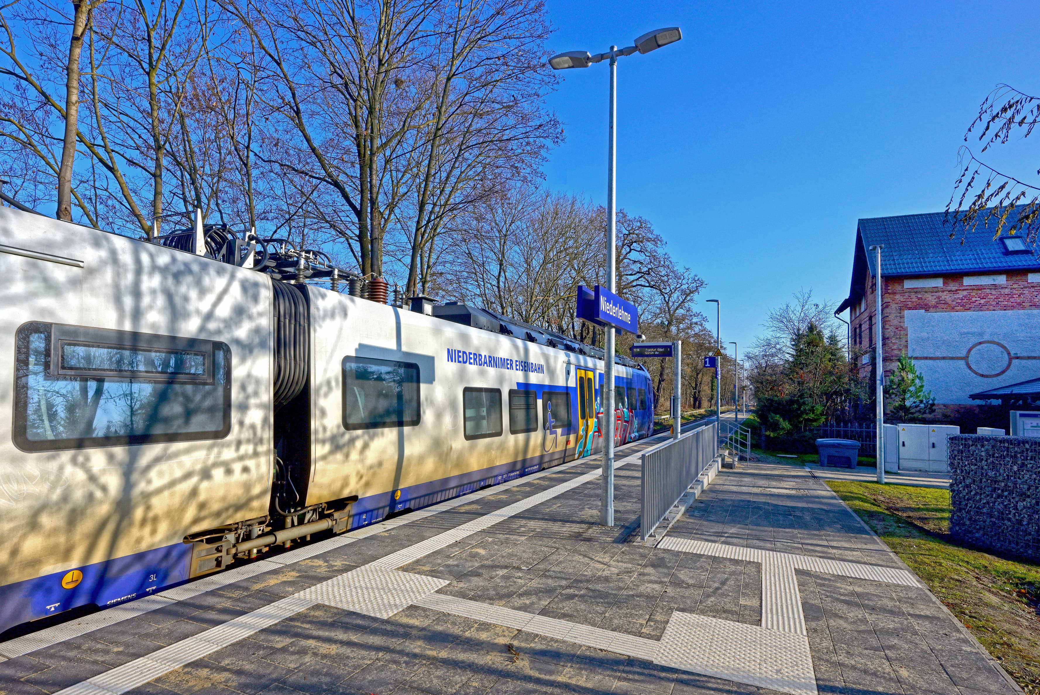 Der neue Bahnsteig mit Zug im Sonnenlicht.