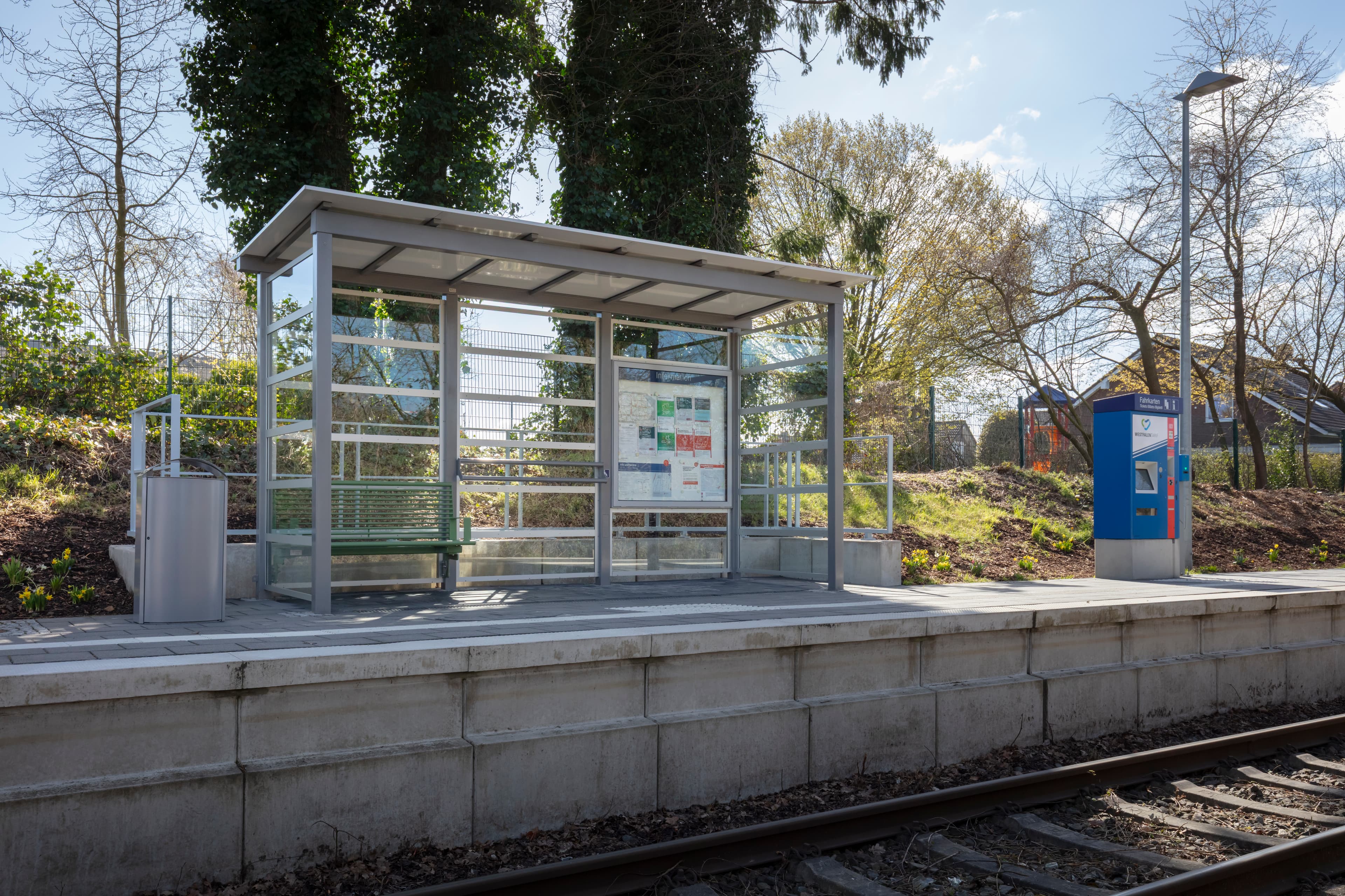 Blick auf das neue lichtdurchlässige Wetterschutzhäuschen mit neuer komfortabler Sitzbank.