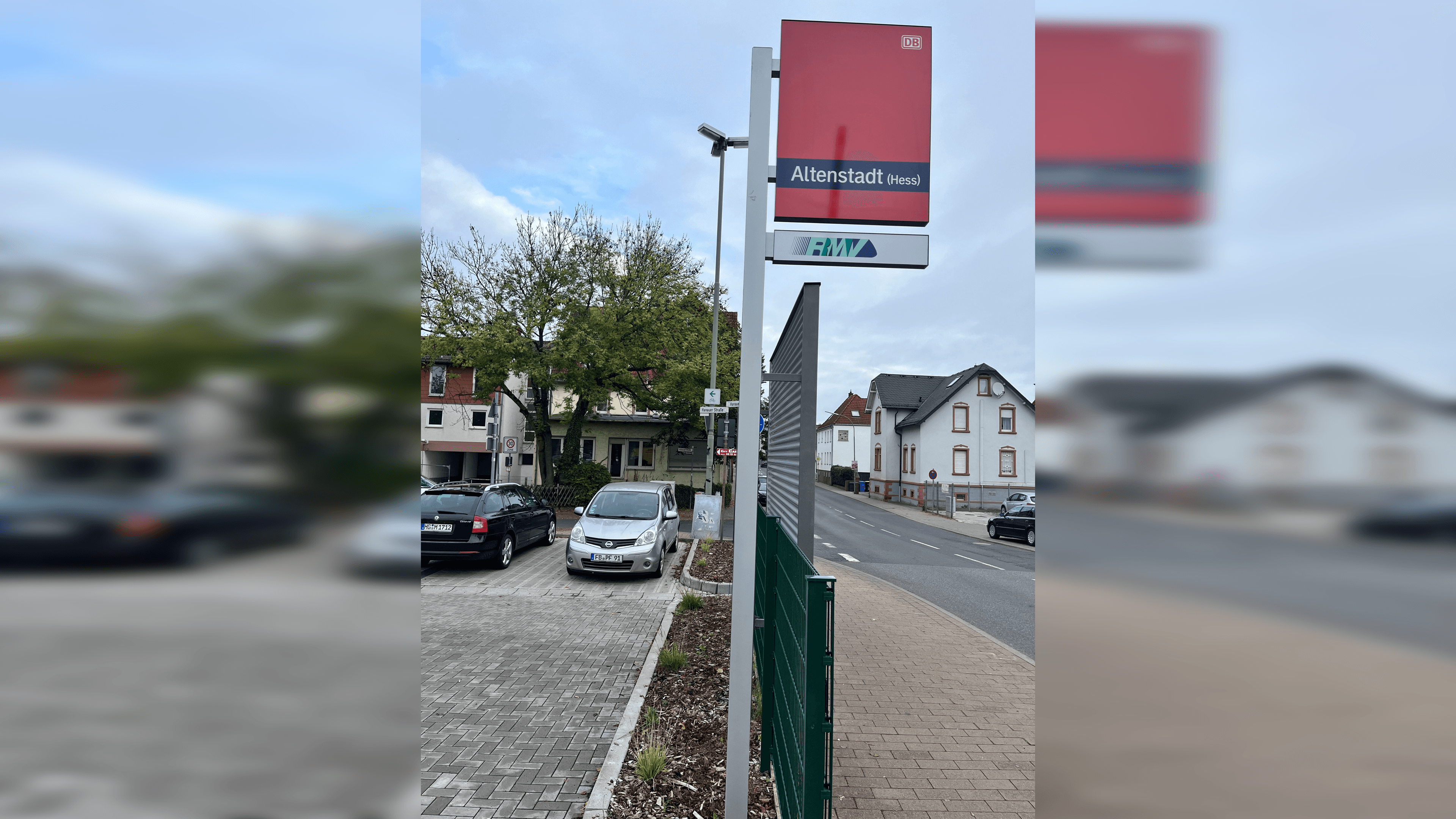 Blick auf die neue Bahnhofsfahne. Im Hintergrund sind Häuser und Autos zu erkennen.