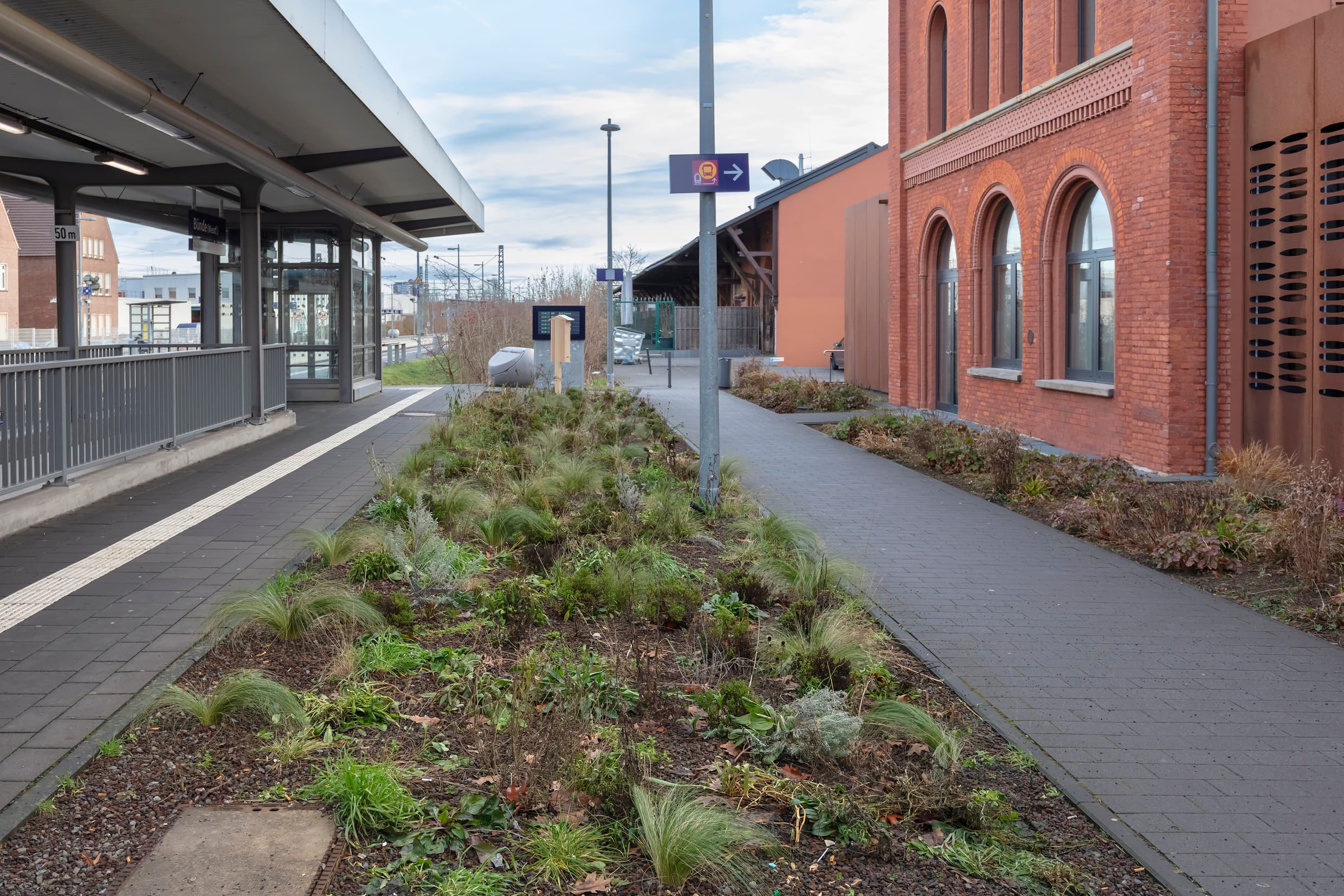 Neuer Grünstreifen und Insektenhotel zwischen Bahnhofsgebäude und Bahnsteig.