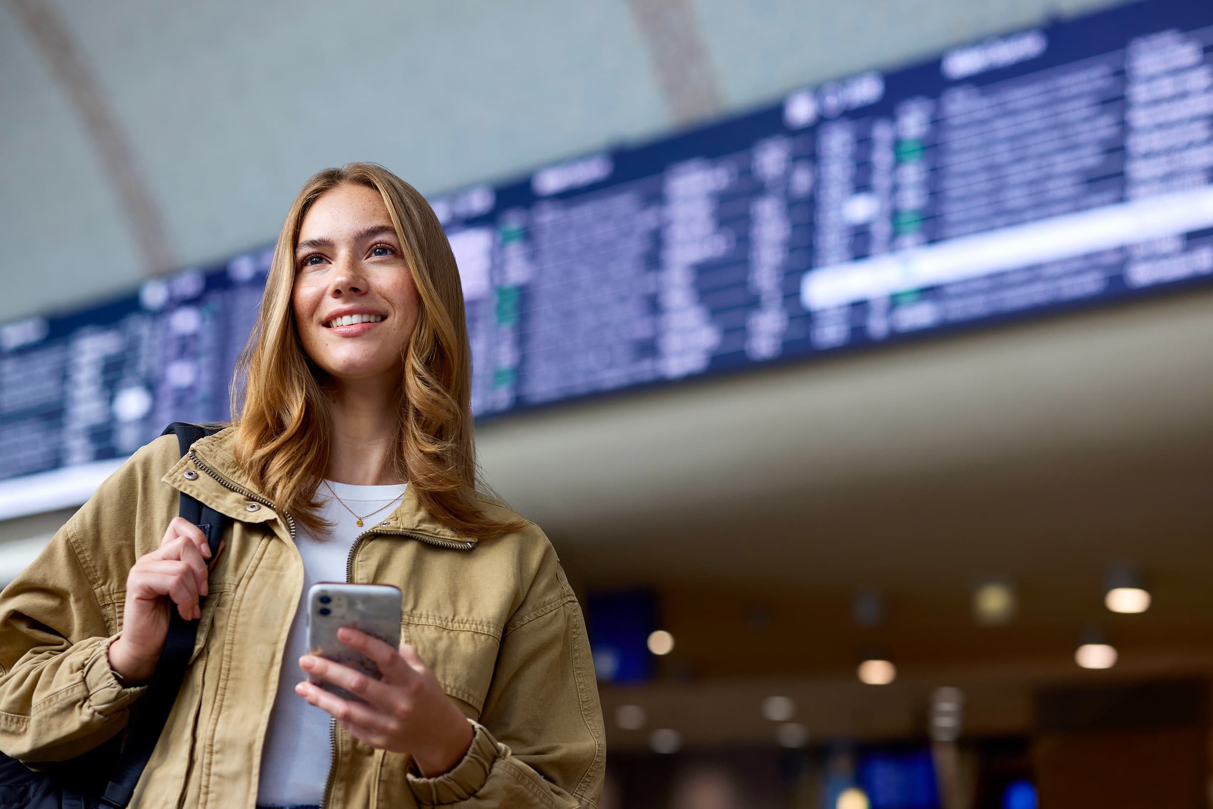 Reisende mit Smartphone im Hauptbahnhof Köln.