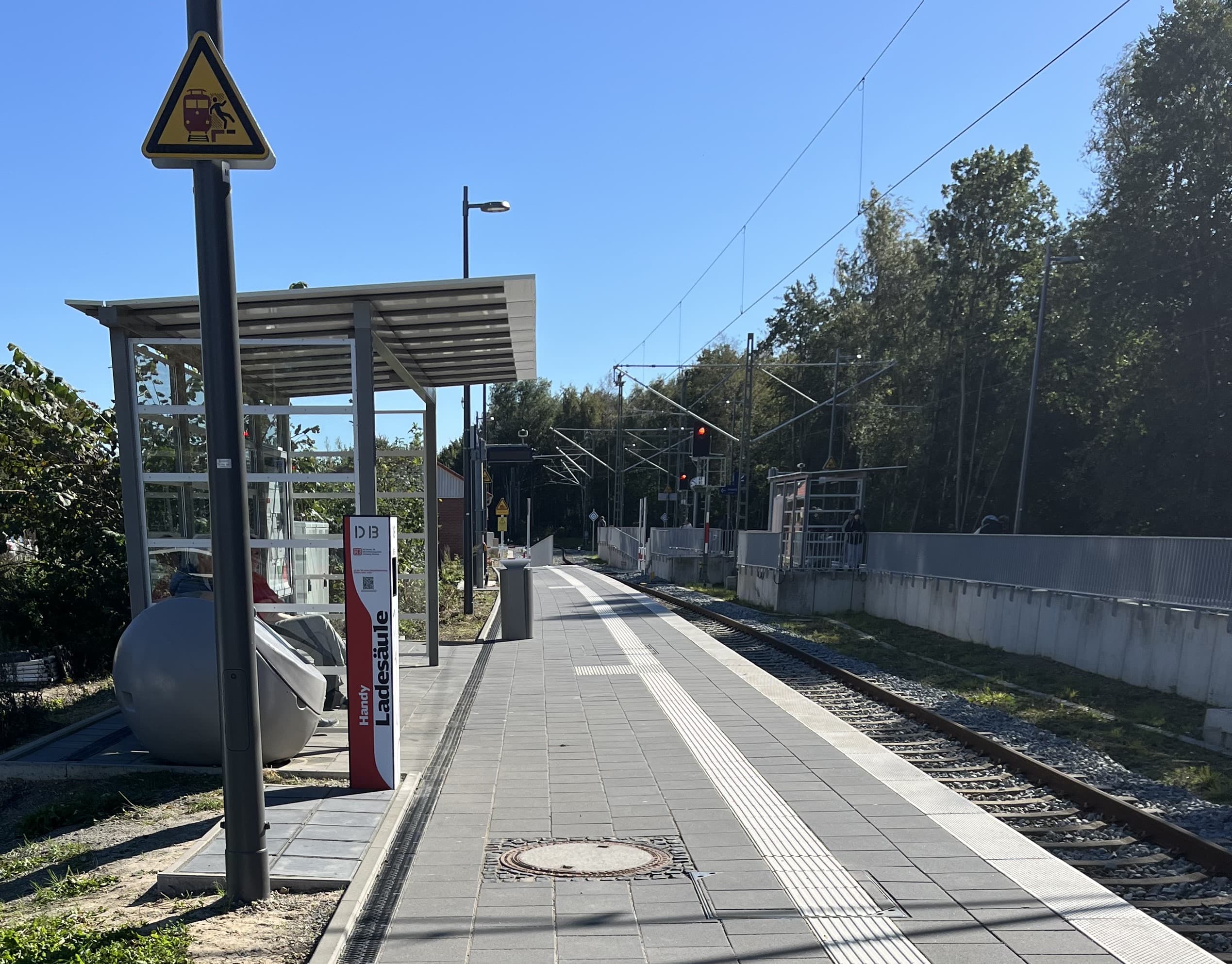 Der Bahnsteig an Gleis 1 mit gläsernem Wartehaus und Handy-Ladesäule.